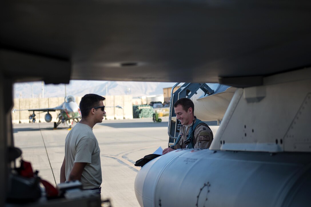 U.S. Air Force Capt. Tyler McBride, right, goes over preflight procedures with U.S. Air Force Airman 1st Class Christian Lamb on Bagram Airfield, Afghanistan, Oct. 30, 2015. McBride is a pilot assigned to the 421st Expeditionary Fighter Squadron and Lamb is a crew chief assigned to the 455th Expeditionary Aircraft Maintenance Squadron. U.S. Air Force photo by Tech. Sgt. Joseph Swafford