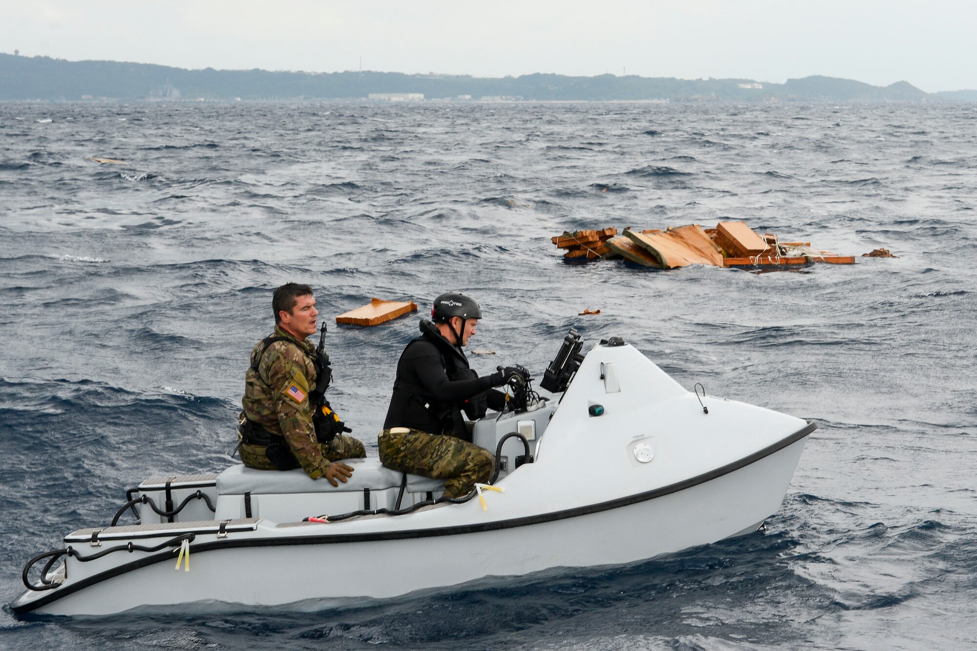 Master Sgt. Shane Hargis, a 212th Rescue Squadron pararescueman, and Maj. Jay Casello, a 212th RQS combat rescue officer, begin a mock search for survivors aboard a guardian angel rescue craft Oct. 31, 2015, near the coast of White Beach Naval Base, Japan. The rescue team was airdropped by a C-17 Globemaster from Alaska Air National Guard’s 249th Airlift Squadron in a long range search and rescue exercise. (U.S. Air Force photo/Senior Airman John Linzmeier)