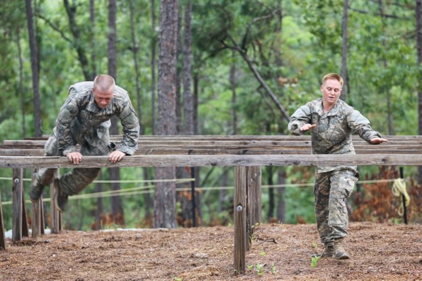 Maj. Lisa Jaster, right, tackles the hurdles at the Darby Queen obstacle course as part of training at the Ranger course on Fort Benning, Ga., June 28, 2015.