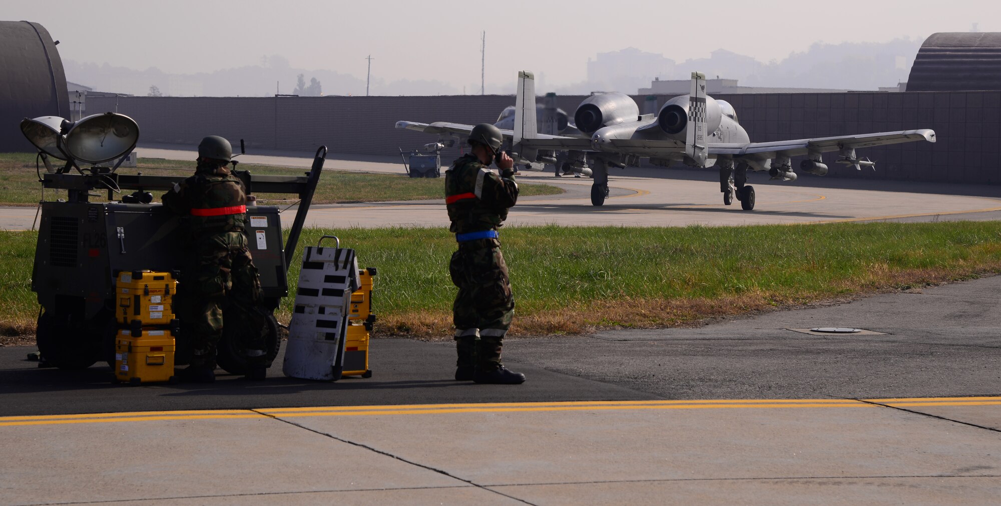 Airmen participating in readiness exercise Vigilant Ace 16 work on the flightline while two A-10 Thunderbolt IIs taxi past after a mission Nov. 3, 2015, at Osan Air Base, Republic of Korea. Members assigned to more than 8 squadrons from three separate bases across Pacific Air Forces are participating in readiness exercise Vigilant Ace 16. Vigilant Ace 16 is a large-scale exercise designed to enhance the interoperability of the U.S. and Republic of Korea Air Forces. (U.S. Air Force photo/Staff Sgt. Benjamin Sutton)