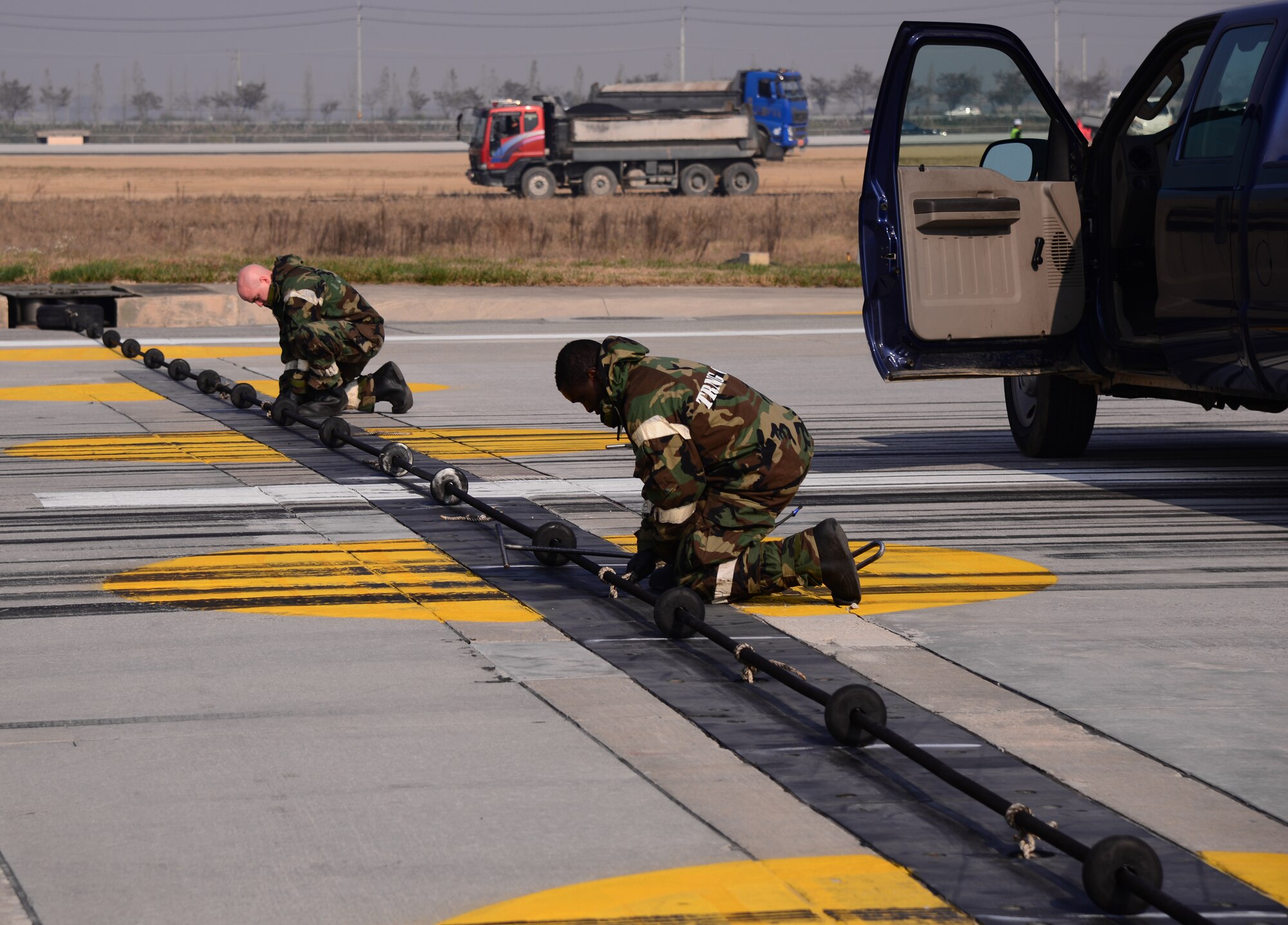 Airmen assigned to 51st Civil Engineer Squadron barrier management flight raise a barrier cable in the event a fighter jet over shoots the runway or during an emergency Nov. 3, 2015, at Osan Air Base, Republic of Korea. Barrier management airmen and airfield managers from the 51st Fighter Wing ensure the flightline is operational for aircraft participating in readiness exercise Vigilant Ace 16. Vigilant Ace 16 is a large-scale exercise designed to test the combat capabilities and enhance the interoperability of the U.S. and Republic of Korea Air Forces. (U.S. Air Force photo/Staff Sgt. Benjamin Sutton)