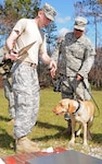 Army Capt. Michael Bellin, veterinarian assigned to Gulf Coast District Veterinary Command, asks Army Spc. Zach Laker, a Tactical Explosive Detection Dog handler and infantryman assigned to Alpha Company, 1-148th Infantry, 37th Infantry Brigade Combat Team, to escort Sassy, his TEDD, to the scales during a check-up at Camp Shelby Joint Forces Training Center, Nov. 7, 2011. The 37th IBCT will be utilizing TEDDs during their upcoming deployment to Afghanistan in support of Operation Enduring Freedom.