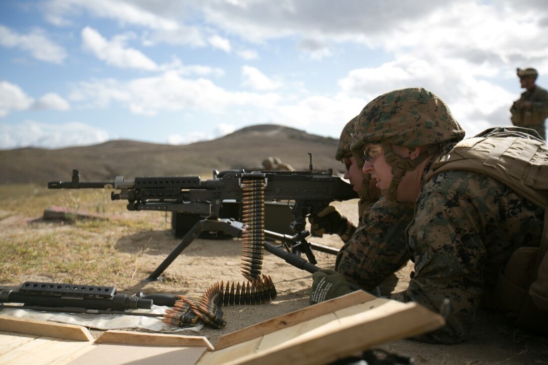 Cpl. Nichles Milone, a food service specialist with the 11th Marine Expeditionary Unit (11th MEU), serves as an assistant gunner for Staff Sgt. Jacob Byers, the senior intelligence analyst with the  11th MEU, as he fires an M240B machine gun during crew served weapons training at Camp Pendleton, Calif., Nov. 3, 2015. Crew served weapons training develops Marines efficiency with the M240B machine gun and M249 light machine gun, and reinforces combat readiness. (U.S. Marine Corps photo by Cpl. Xzavior T. McNeal)