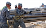 Citizen-Soldiers from the 1729th Field Support Maintenance Company from Havre de Grace, Md., secure pipes to a forklift on Contingency Operating Base Adder, Iraq, Nov. 2, 2011.