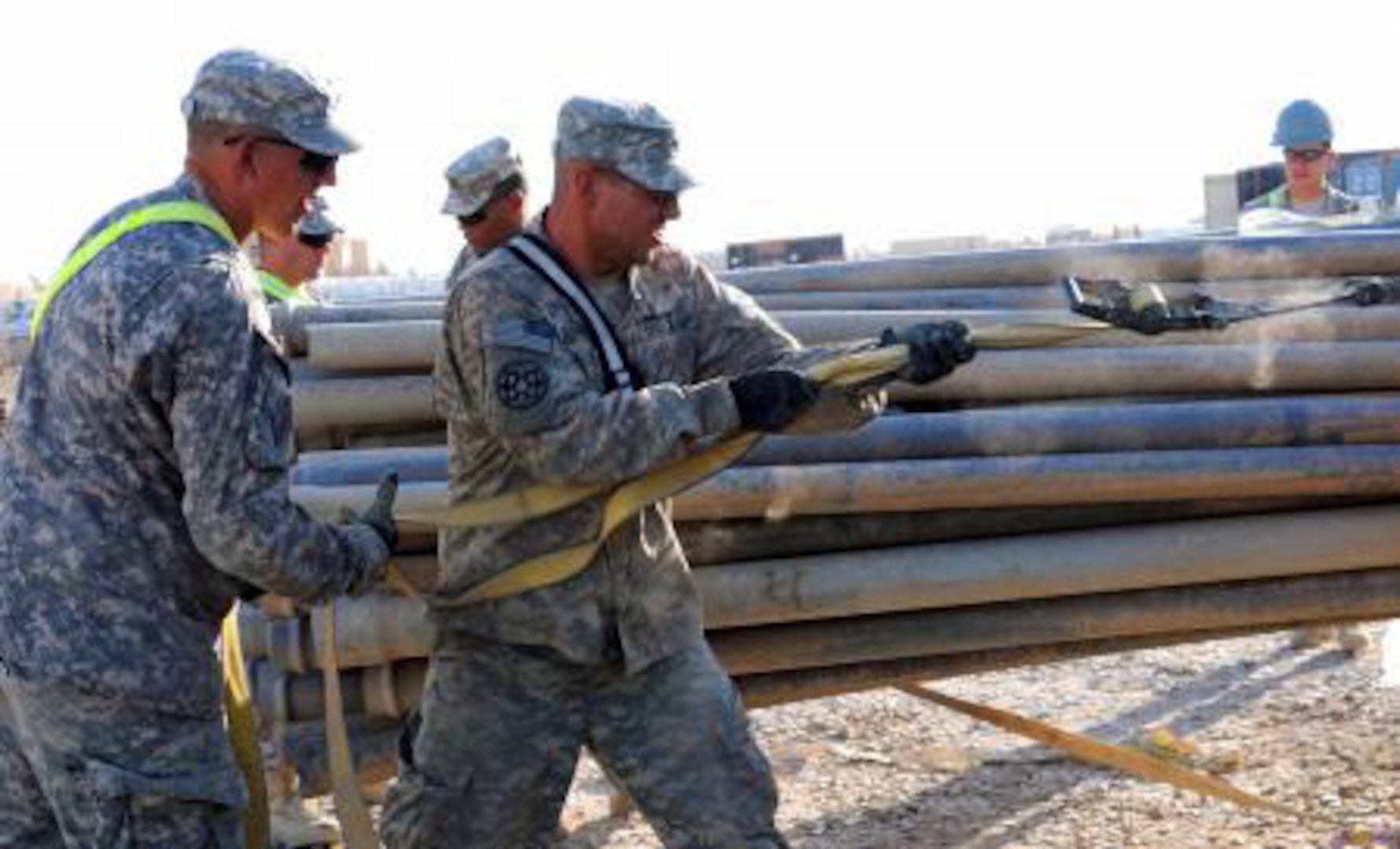 Citizen-Soldiers from the 1729th Field Support Maintenance Company from Havre de Grace, Md., secure pipes to a forklift on Contingency Operating Base Adder, Iraq, Nov. 2, 2011.