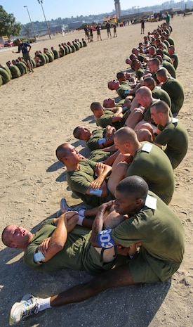 Recruits of India Company, 3rd Recruit Training Battalion, conduct crunches during a final physical fitness test at Marine Corps Recruit Depot San Diego, Oct. 22. Recruits had two minutes to conduct a maximum set of pull-ups while their partner counted each repetition out loud. Today, all males recruited from west of the Mississippi are trained at MCRD San Diego. The depot is responsible for training more than 16,000 recruits annually. India Company graduates Nov. 6.
