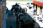 Army Master Sgt. Scott Cutter, Wolf Operations Group acting command sergeant major, (upper right) watches to see how his military personnel perform during a joint civilian-military exercise in the Afghan Marketplace at Muscatatuck Urban Training Center.