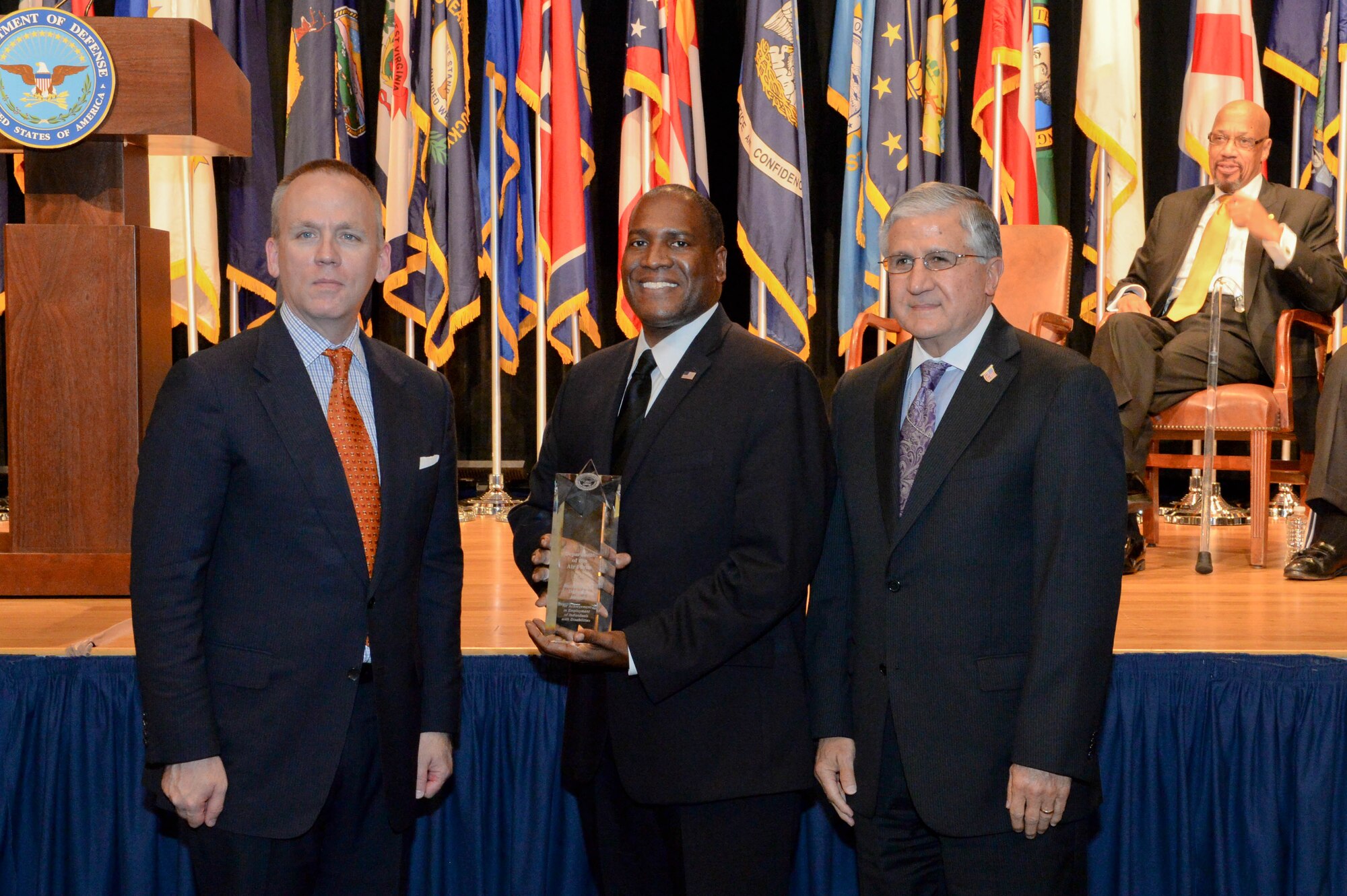 Brad Carson, the acting undersecretary of defense for personnel and readiness, presents the secretary of defense award for the best disability program among large military components to Bob Corsi, the assistant deputy chief of staff of manpower, personnel and services, and Dr. Jarris Taylor, deputy assistant secretary of strategic diversity integration, during a ceremony at the Pentagon Oct. 29, 2015. For the past 35 years, the Office of Diversity Management and Equal Opportunity has recognized outstanding service members and Defense Department civilian personnel with disabilities at an annual awards ceremony. (U.S. Army photo/Sgt. Courtney Russell)