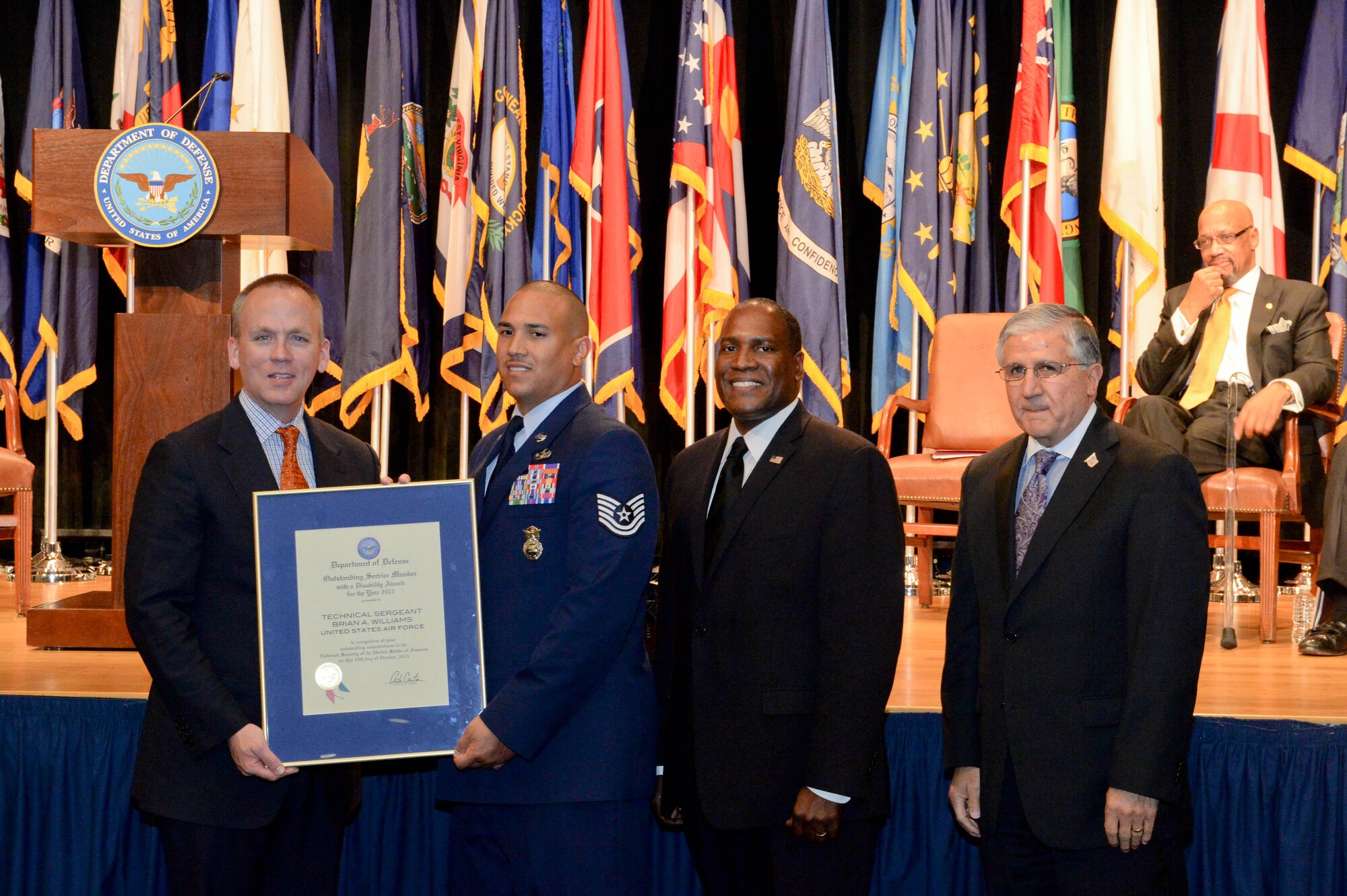 Brad Carson, the acting undersecretary of defense for personnel and readiness, presents Tech. Sgt. Brian Williams, an 87th Security Forces Squadron military working dog trainer at Joint Base McGuire-Dix-Lakehurst, N.J., with a secretary of defense award to outstanding civilian and service members with disabilities during a ceremony at the Pentagon Oct. 29, 2015. (U.S. Army photo/Sgt. Courtney Russell)