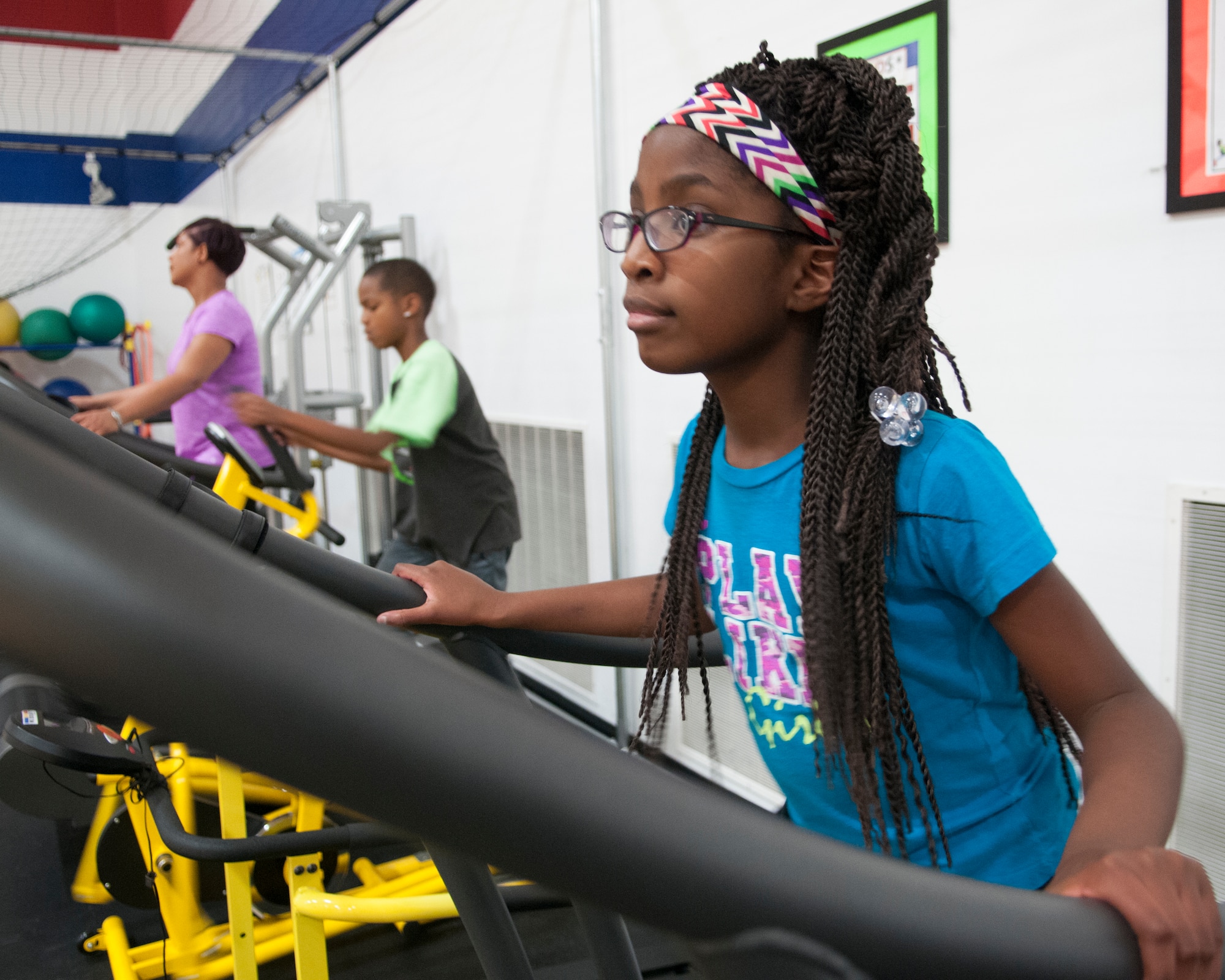 Imani Stewart, 9, runs on a treadmill next to her brother and mother during their workout in the Freedom Hall Fitness Center’s Parent Youth Fitness Area, Oct. 28, 2015, on F.E. Warren Air Force Base, Wyo. Children, ages 6 through 12, have access to the exercise equipment alongside their parents. (U.S. Air Force photo by Airman 1st Class Malcolm Mayfield)