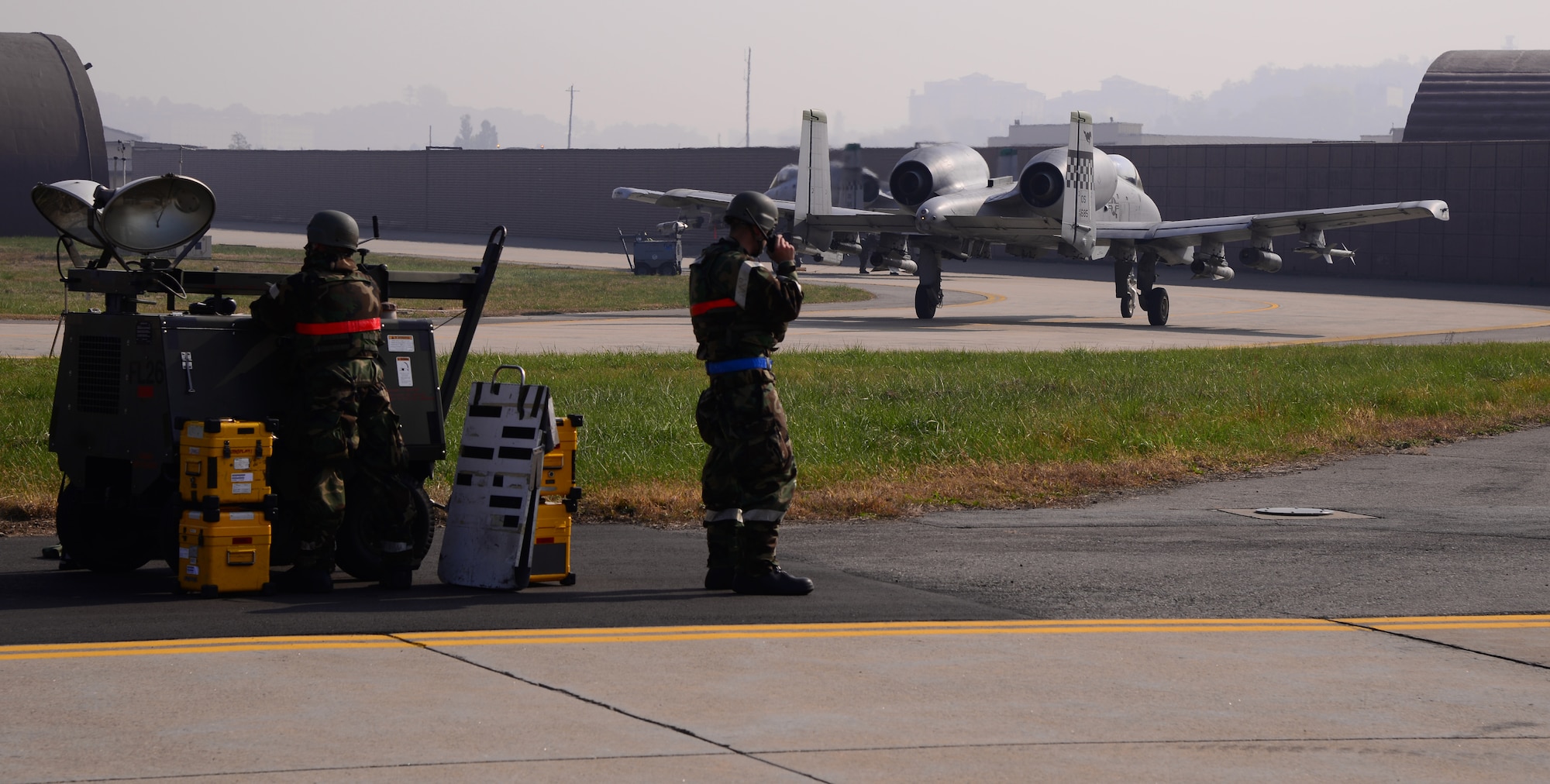 Airmen participating in readiness exercise Vigilant Ace 16 work on the flightline while two A-10 Thunderbolt IIs taxi past after a mission Nov. 3, 2015, at Osan Air Base, Republic of Korea.  Members assigned to more than 8 squadrons from three seperate bases across Pacific Air Forces are participating in readiness exercise Vigilant Ace 16. Vigilant Ace 16 is a large-scale exercise designed to enhance the interoperability of the U.S. and Republic of Korea Air Forces. (U.S. Air Force photo/Staff Sgt. Benjamin Sutton)