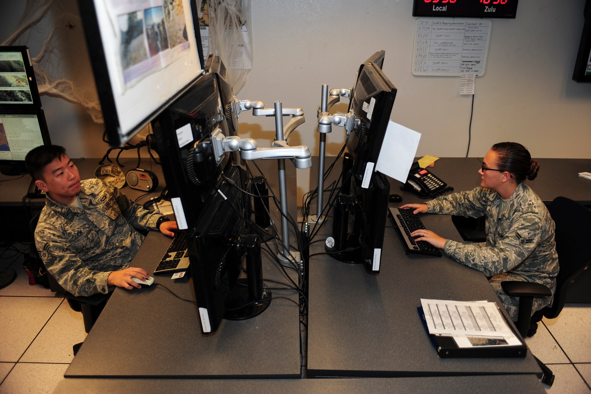U.S. Air Force Senior Airmen James Kim and Airman 1st Class Ariel Hawkins, 25th Operational Weather Squadron weather forecasters, monitor weather conditions at Davis-Monthan Air Force Base, Ariz., Oct. 29, 2015. The 25th OWS operations floor is divided into north, south and central sections, forecasting the weather for the Western part of the Continental U.S. (U.S. Air Force photo by Airman Basic Nathan H. Barbour/Released)