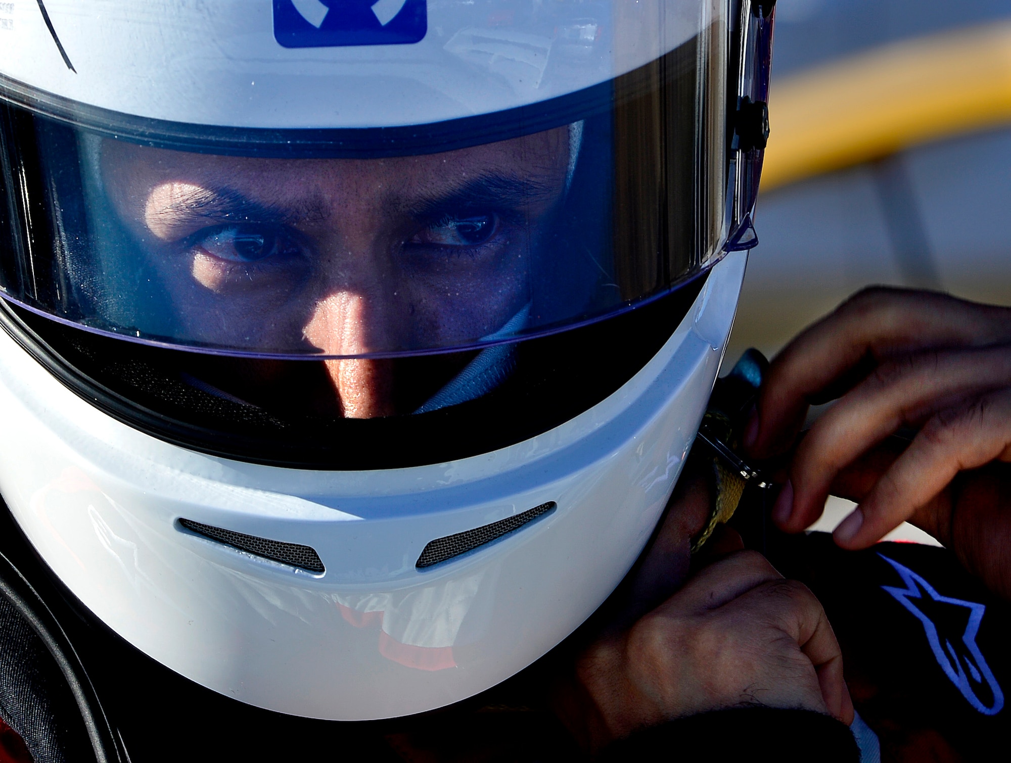 Tech. Sgt. Gabriel, 432nd Wing/432nd Air Expeditionary Wing MQ-9 Reaper sensor operator, puts his helmet on before racing his Mitsubishi Lancer Evolution at the Spring Mountain Raceway Nov. 1, 2015, in Pahrump, Nevada. Gabriel balances his life between a highly stressful, yet rewarding career, with his passion for cars and racing. (U.S. Air Force photo by Airman 1st Class Christian Clausen/Released)