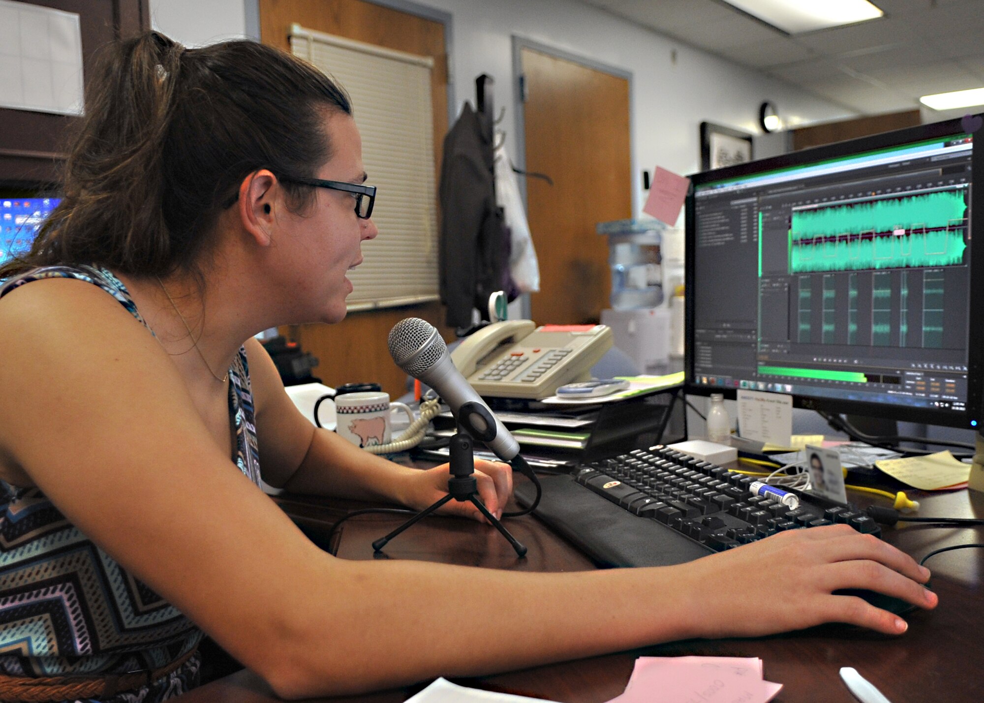 Aliese Halcomb, 325th Force Support Squadron graphic illustrator, operates audio editing software to incorporate music and advertisement recordings into their on-hold systems Oct. 28 in the marketing office at Military Personnel Section building. This system will be used to better inform callers of events being hosted by agencies on the installation. (U.S. Air Force photo by Senior Airman Ty-Rico Lea/Released)
