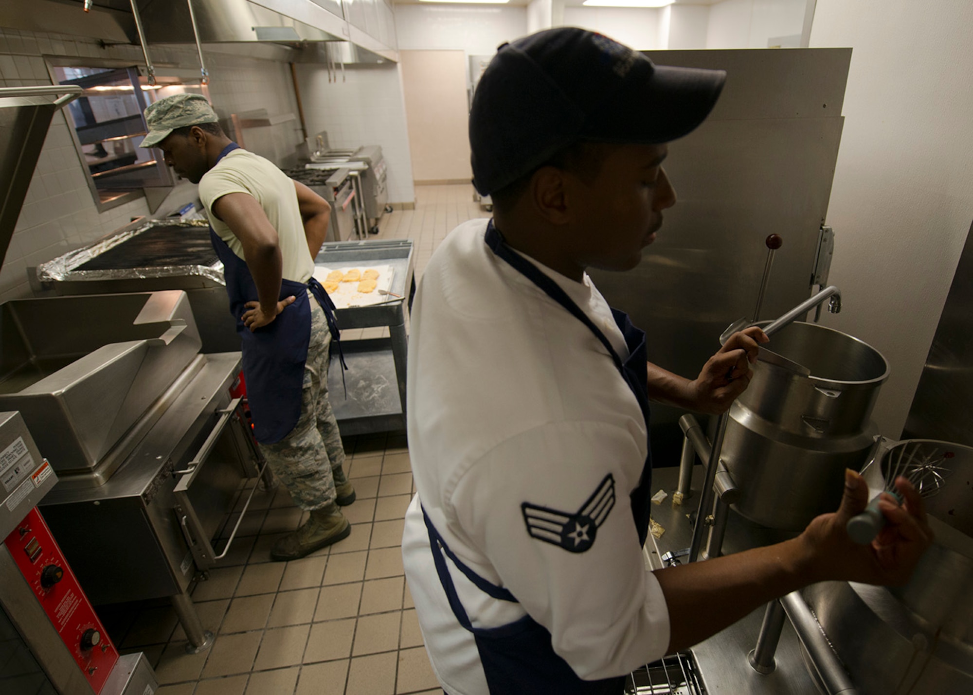 U.S. Air Force Senior Airmen Fritz Javel and Damian Jefferson, 633rd Force Support Squadron services journeyman, prepare lunch in the Raptor Café at Langley Air Force Base, Va. Oct. 30, 2015. The flight line kitchen serves 180 personnel daily. (U.S. Air Force photo by Staff Sgt. John D. Strong II/Released)