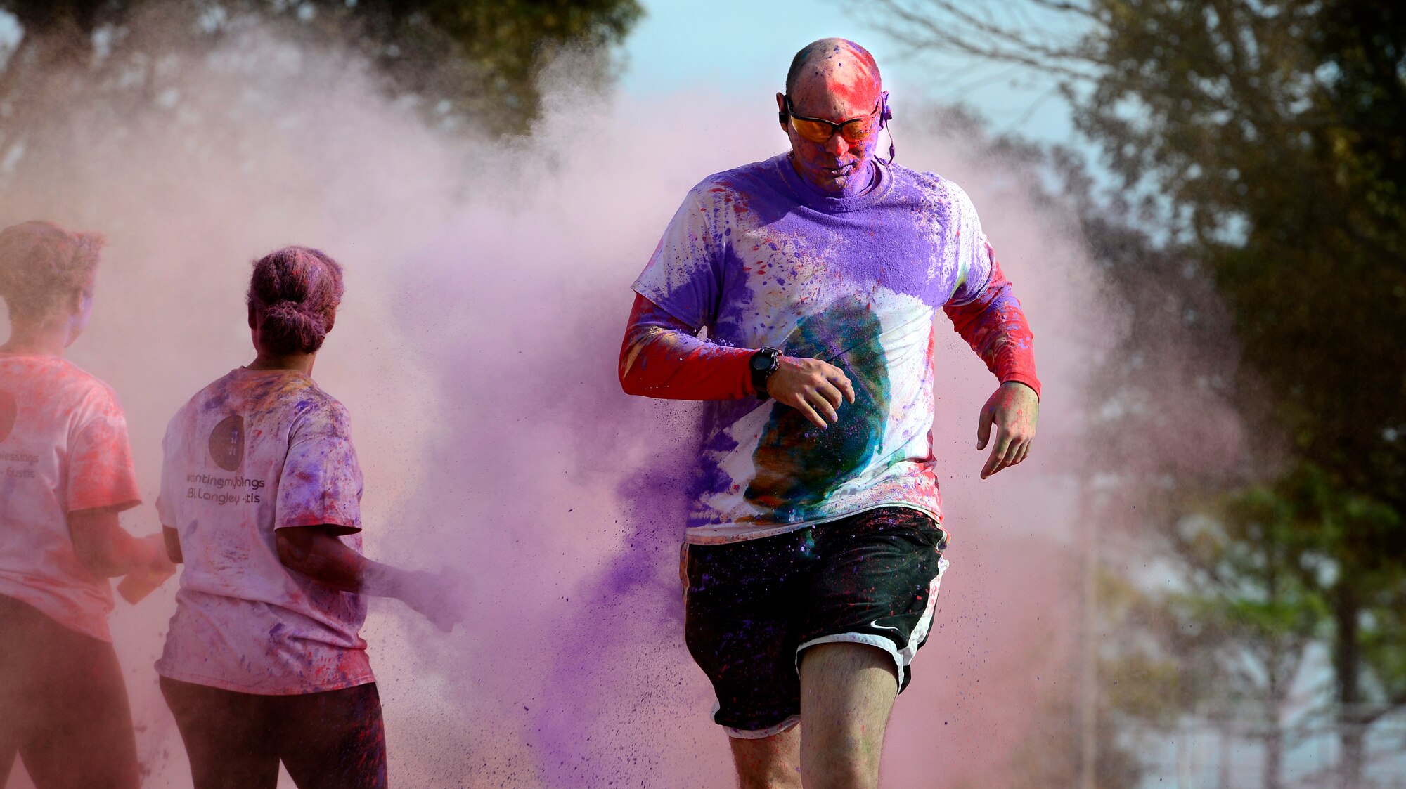 A runner passes through the finish line during the Joint Base Langley-Eustis Resiliency 5K Color Run at Langley Air Force Base, Va., Oct. 29, 2015. The run was open to all JBLE U.S. Service members, family members and Department of Defense civilians.  (U.S. Air Force photo by Senior Airman Kayla Newman/Released)