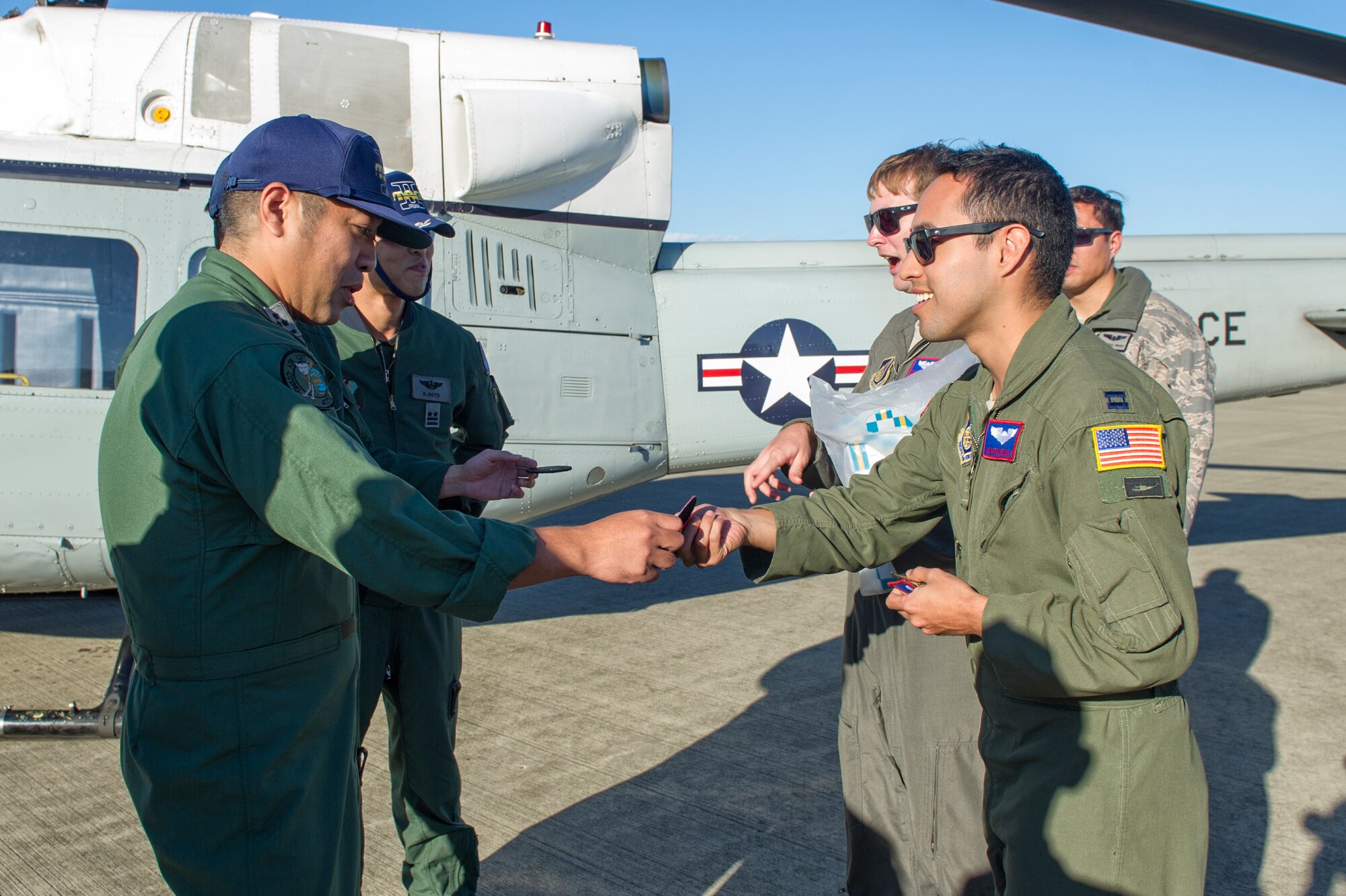Capt. Jonathan Bonilla, 459th Airlift Squadron UH-1N Huey pilot, exchanges flight suit patches with a Japan Air Self-Defense Force Airman at Iruma Air Base, Japan, Nov. 3, 2015. The 459th Airlift Squadron’s participation in the annual air show allowed Yokota Airmen an opportunity to build relationships with their Japan Air Self-Defense Force partners and interact with the members of the local community. (U.S. Air Force photo by Airman 1st Class Delano Scott/Released)