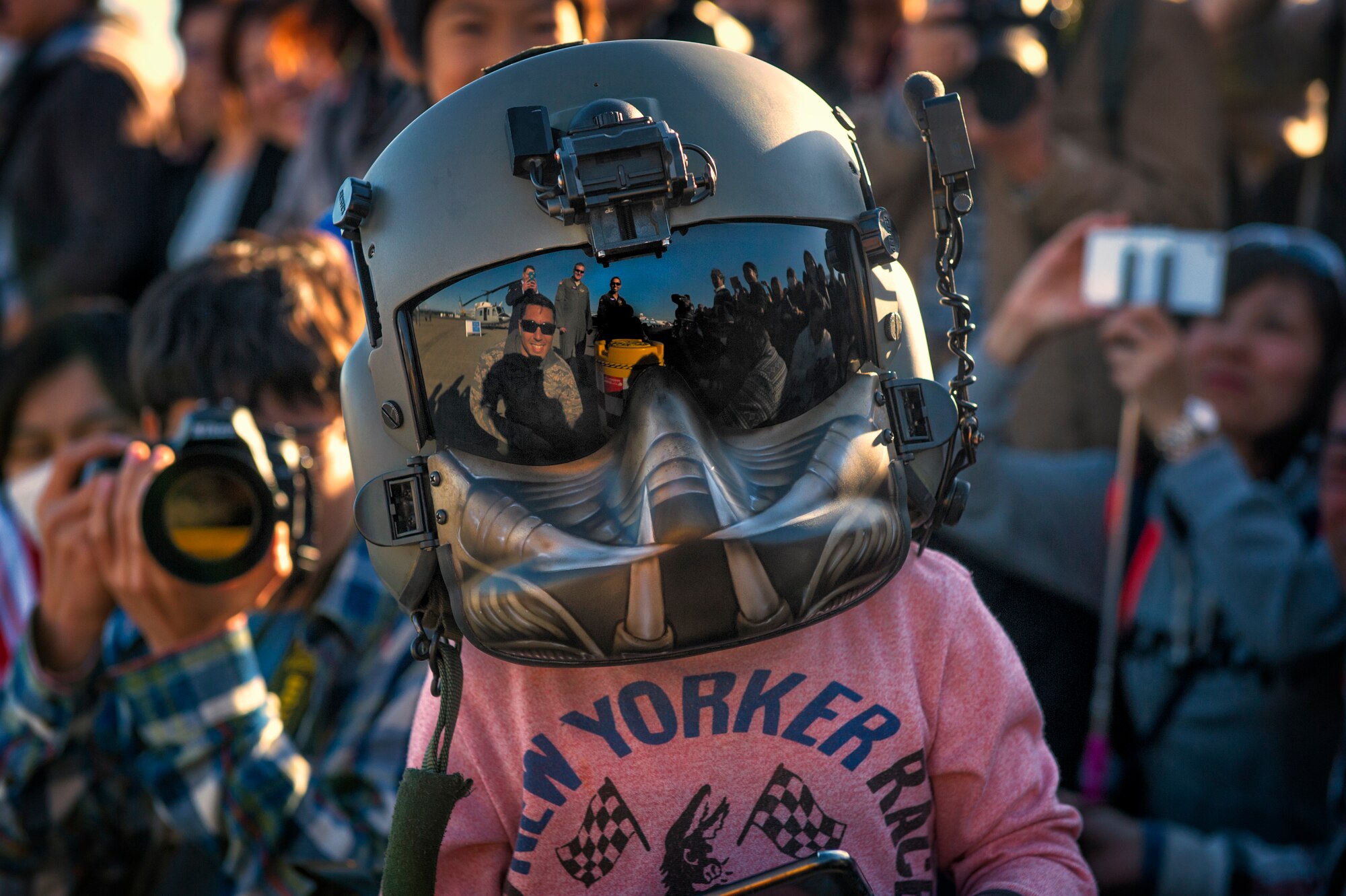 A child tries on the helmet of Tech. Sgt.  Michael Wright, 459th Airlift Squadron UH-1N Huey flight engineer, at Iruma Air Base, Japan, Nov. 3, 2015. The 459th Airlift Squadron’s participation in the annual air show allowed Yokota Airmen an opportunity to build relationships with their Japan Air Self-Defense Force partners and interact with the members of the local community. (U.S. Air Force photo by Airman 1st Class Delano Scott/Released)