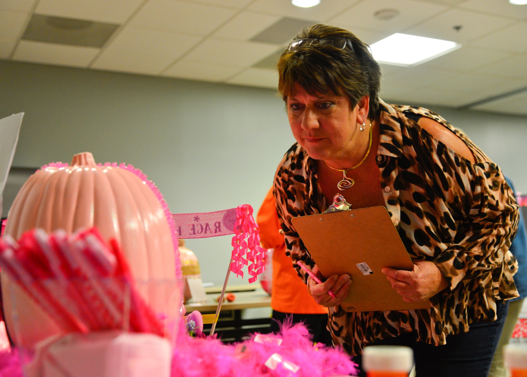 Donna Stanley, 436th Medical Support Squadron accounting manager and breast cancer survivor, judges a pumpkin during the pink pumpkin contest Oct. 28, 2015, at the 436th Medical Group Clinic on Dover Air Force Base, Del. Each squadron within the medical group painted and decorated pumpkins to reflect a breast cancer awareness theme and the winner was announced at the Woman’s Health Event. (U.S. Air Force photo/Senior Airman William Johnson)