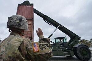 U.S. Army Spc. Brandon Dominguez, Maritime and Intermodal Training School student, directs Pfc. Richard Jones, Maritime and Intermodal Training School student, during the rough terrain container handler course at Fort Eustis, Va., Oct. 28, 2015. The program teaches experienced Soldiers enhanced cargo loading and operating skills.  (U.S. Air Force photo by Staff Sgt. Natasha Stannard/ Released)