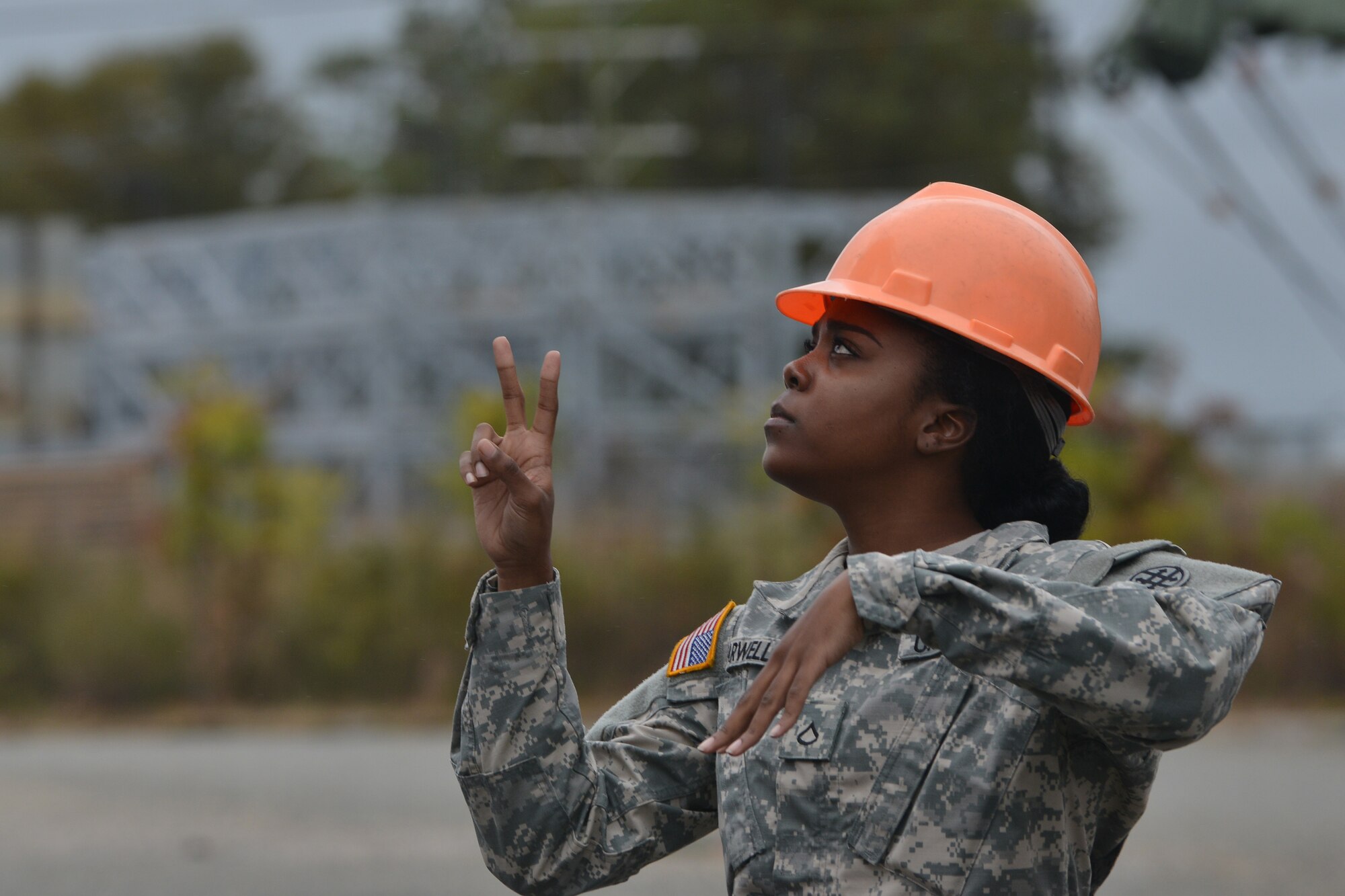 U.S. Army Pfc. Shaunteria Farwell, Maritime and Intermodal Training School student, assists an operator during the rough terrain container handler course at Fort Eustis, Va., Oct. 28, 2015. The course is made up of active duty and Reserve students, one of whom is Farwell, a logistics specialist with the 79th Quartermaster Company out of Houston, Texas. (U.S. Air Force photo by Staff Sgt. Natasha Stannard/ Released)