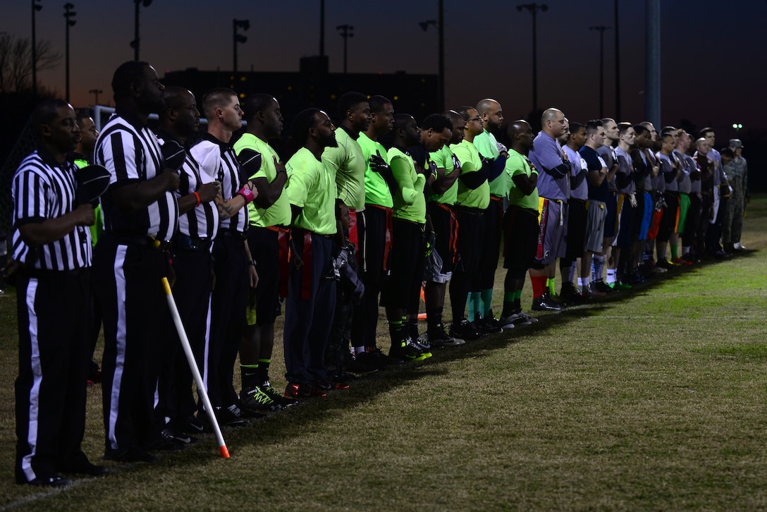 U.S. Air Force Airmen and civilians stand as the national anthem plays prior to the 2015 Intramural Football Championship at Langley Air Force Base, Va., Nov. 3, 2015. The Ryan Center team triumphed against and 45th Intelligence Squadron, with a final score of 20 to 19. (U.S. Air Force photo by Senior Airman Kimberly Nagle/Released) 