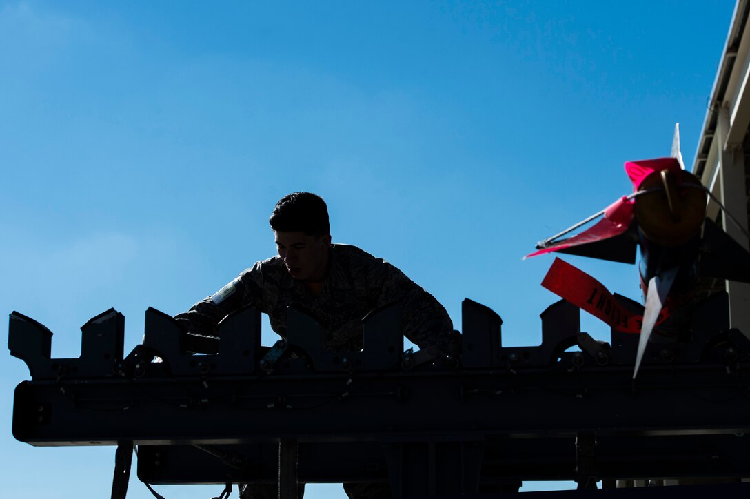 U.S. Air Force Airman 1st Class Andrew Quintero, 27th Fighter Squadron load crew member, competes in the third quarter 1st Maintenance Group weapons load competition at Langley Air Force Base, Va., Oct. 30, 2015. The crews competed to see who could load GBU-32 and AIM 9 missiles into F-22 Raptors the fastest. (U.S. Air Force photo by Senior Airman Kayla Newman/Released)