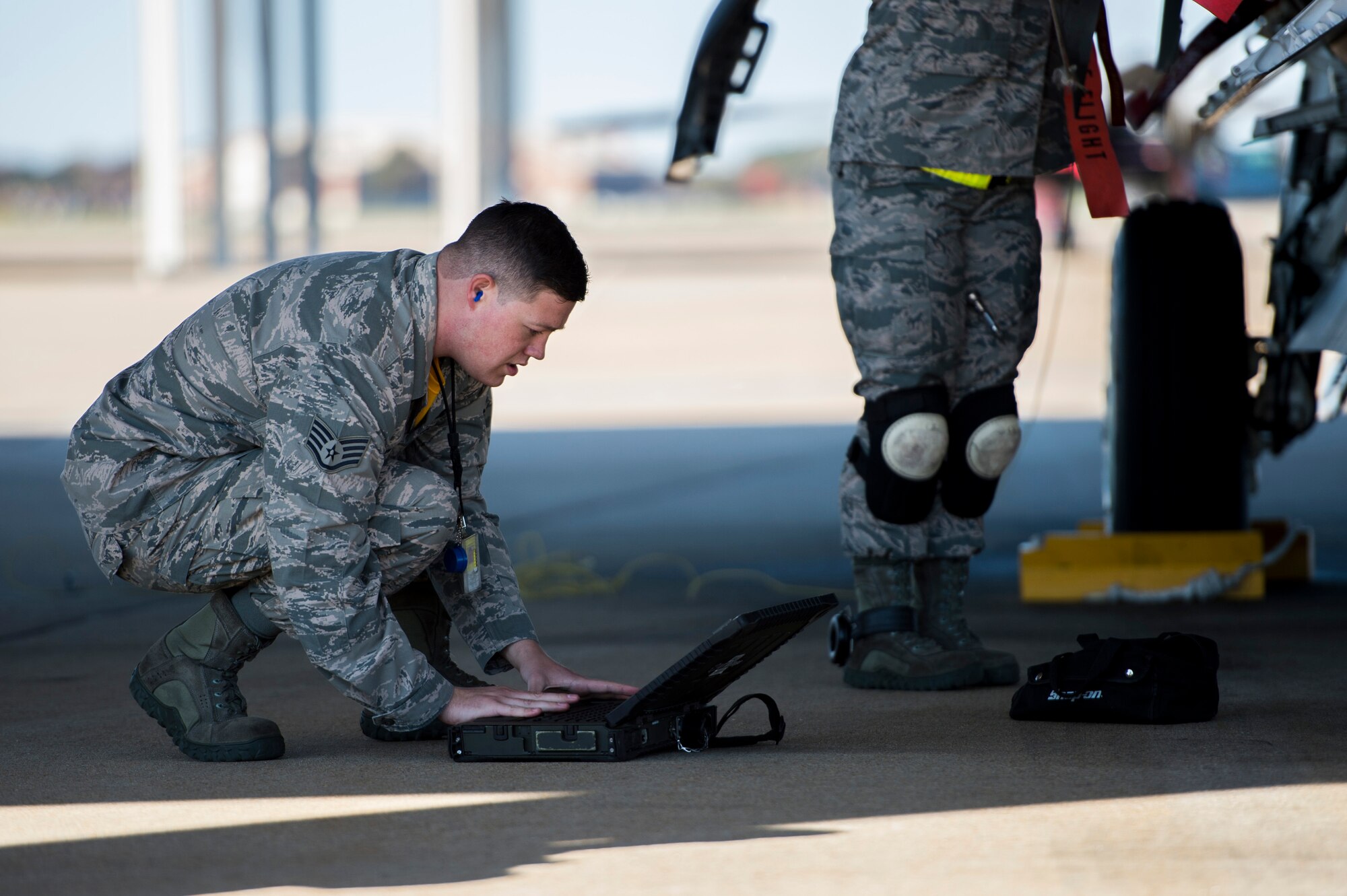 U.S. Air Force Staff Sgt. Cody Brammer, 27th Fighter Squadron load crew member, follows a checklist during a weapons load crew competition at Langley Air Force Base, Va., Oct. 30, 2015. The 27th FS load crew faced off against the 94th FS team for the quarterly competition. (U.S. Air Force photo by Senior Airman Kayla Newman/Released)