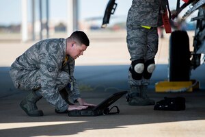 U.S. Air Force Staff Sgt. Cody Brammer, 27th Fighter Squadron load crew member, follows a checklist during a weapons load crew competition at Langley Air Force Base, Va., Oct. 30, 2015. The 27th FS load crew faced off against the 94th FS team for the quarterly competition. (U.S. Air Force photo by Senior Airman Kayla Newman/Released)