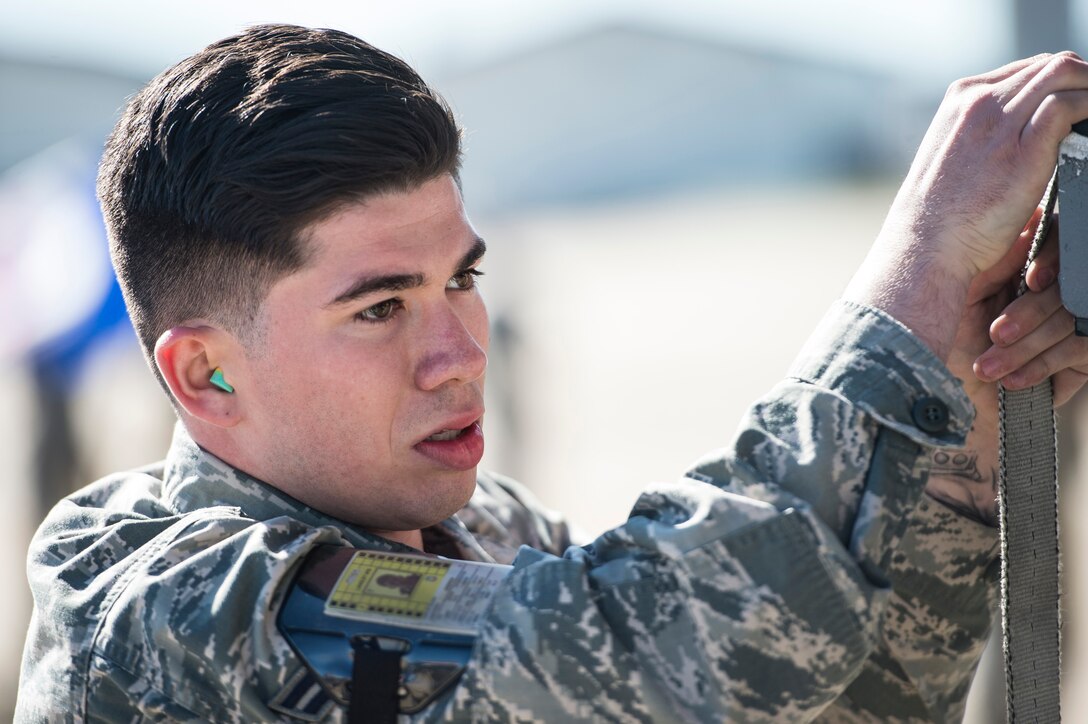 U.S. Air Force Airman 1st Class Andrew Quintero, 27th Fighter Squadron load crew member, fastens the strap on a weapons rack during a competition at Langley Air Force Base, Va., Oct. 30, 2015. The 27th FS load crew beat the 94th FS team by completing the tasks in 26 minutes. (U.S. Air Force photo by Senior Airman Kayla Newman/Released)