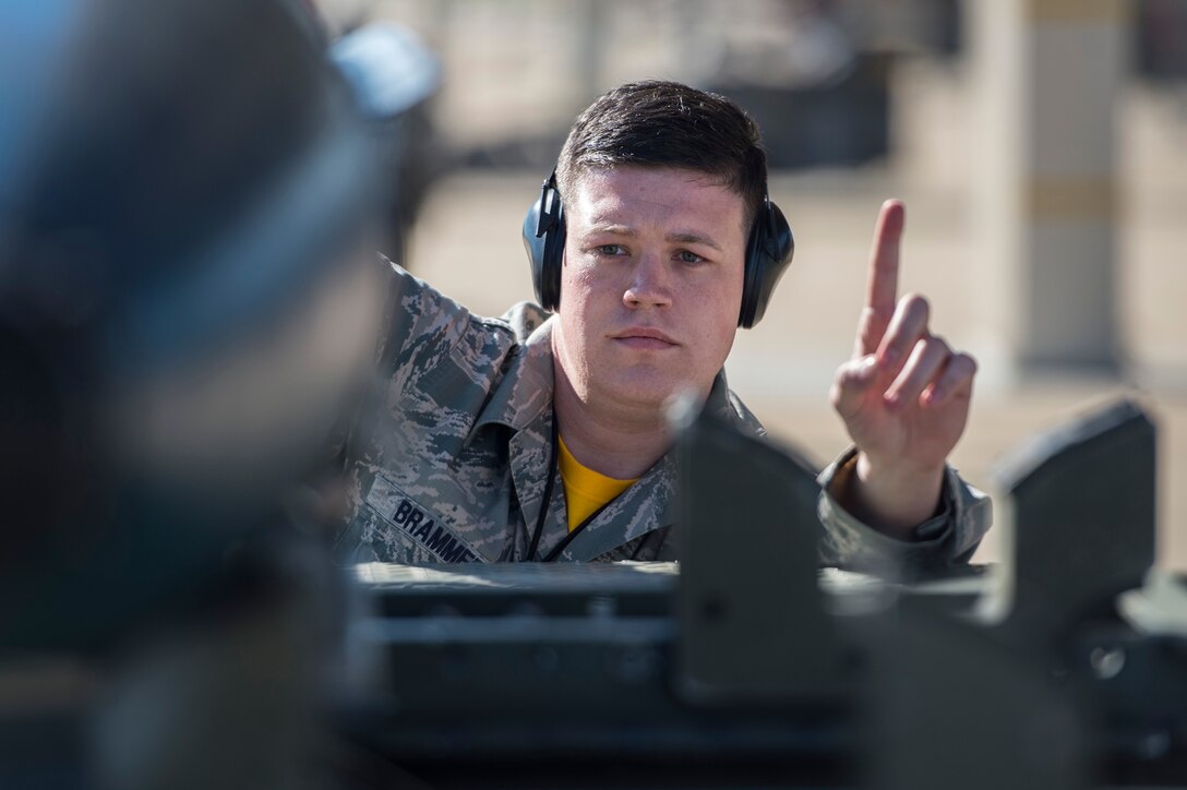 U.S. Air Force Staff Sgt. Cody Brammer, 27th Fighter Squadron load crew member, assists a MJ-1 lift truck operator during a weapons load competition at Langley Air Force Base, Va., Oct. 30, 2015. The 27th FS won the competition by being the first team to load a GBU-32 and two AIM-9 missiles in 26 minutes. (U.S. Air Force photo by Senior Airman Kayla Newman/Released)