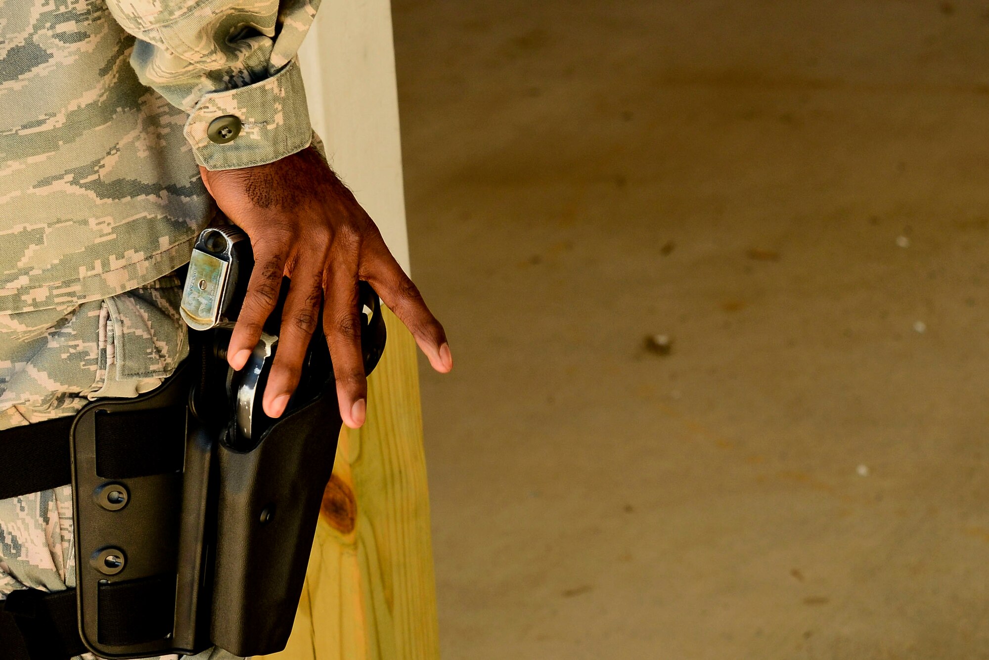 A U.S. Air Force Airman holsters a 9 mm pistol at the Combat Arms Training and Maintenance range at Langley Air Force Base, Va., Oct. 30, 2015. Airmen fired approximately 90 rounds with the Berretta M9 pistol during the hour-long live-fire exercise. (U.S. Air Force photo by Airman 1st Class Derek Seifert/ Released)