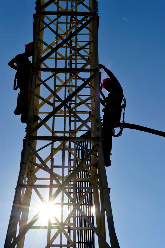 U.S. Air Force Airmen 1st Class Zackery Dwyer and Alexander Acosta, 633rd Communications Squadron cable and antenna maintainers, maintain a cable tower at Langley Air Force Base, Va., Nov. 3, 2015. Cable and antenna maintainers are responsible for upholding the communication infrastructure at Langley. (U.S. Air Force photo by Senior Airman Breonna Veal/Released)