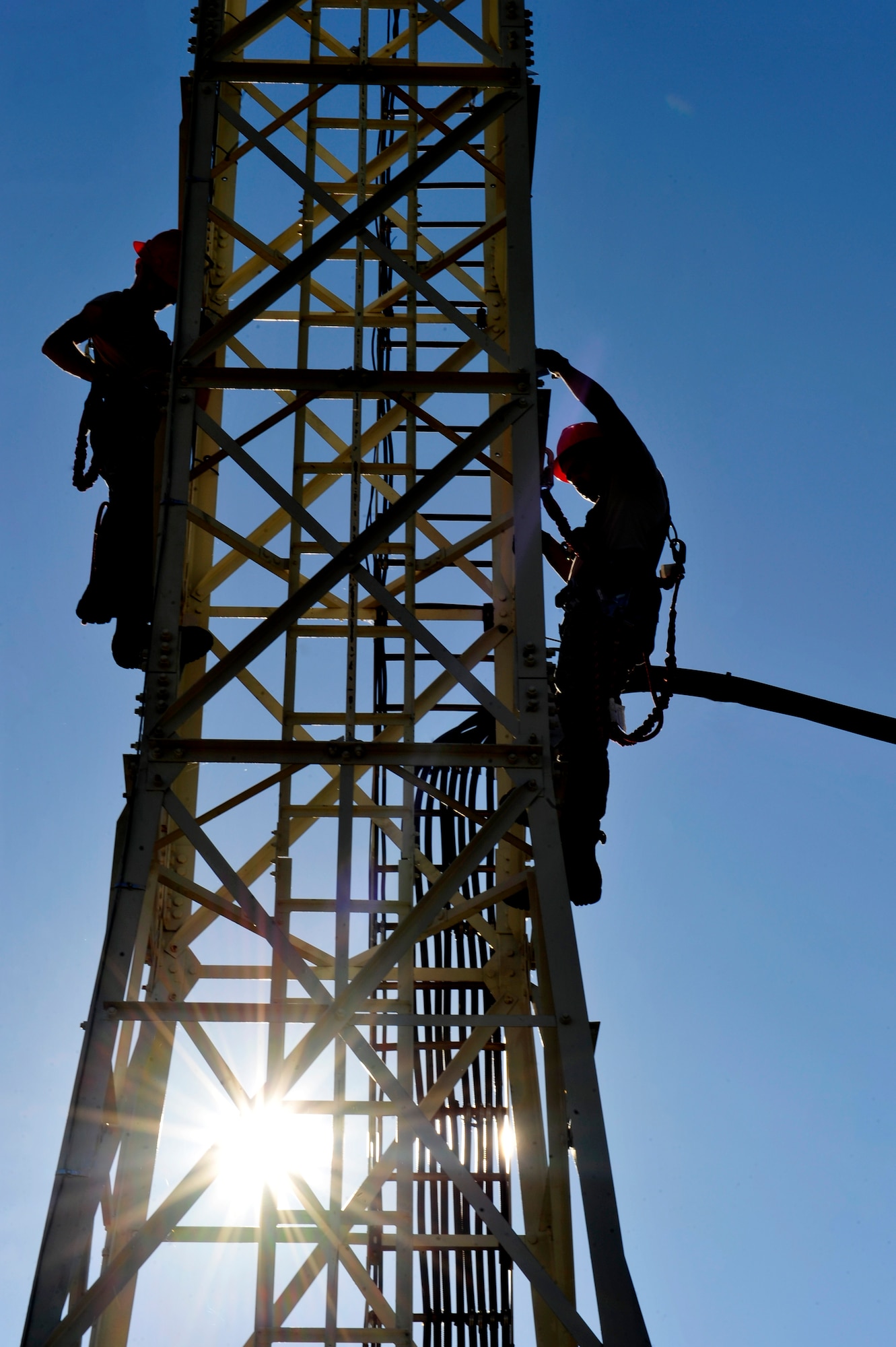 U.S. Air Force Airmen 1st Class Zackery Dwyer and Alexander Acosta, 633rd Communications Squadron cable and antenna maintainers, maintain a cable tower at Langley Air Force Base, Va., Nov. 3, 2015. Cable and antenna maintainers are responsible for upholding the communication infrastructure at Langley. (U.S. Air Force photo by Senior Airman Breonna Veal/Released)