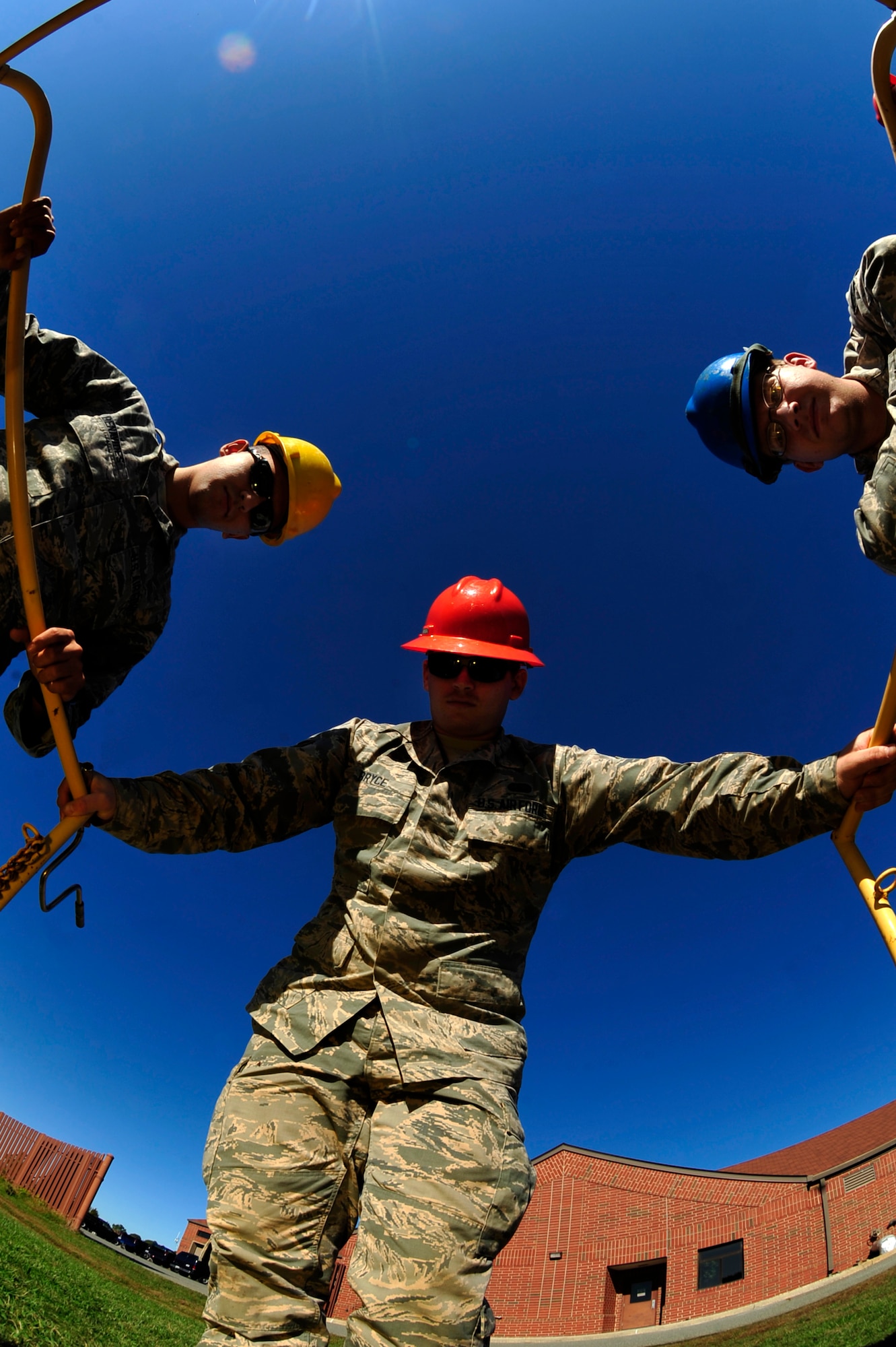 U.S. Air Force Senior Airmen David Benavides and Coy Lawson and Airman 1st Class Ebby Bryce, 633rd Communications Squadron cable and antenna maintainers, observe a manhole at Langley Air Force Base, Va., Nov. 3, 2015. The “Cable Dawgs,” Airmen from the cable and antenna maintenance section, maintain thousands of fiber optic cables that are used to run communication throughout Langley. (U.S. Air Force photo by Senior Airman Breonna Veal/Released) 