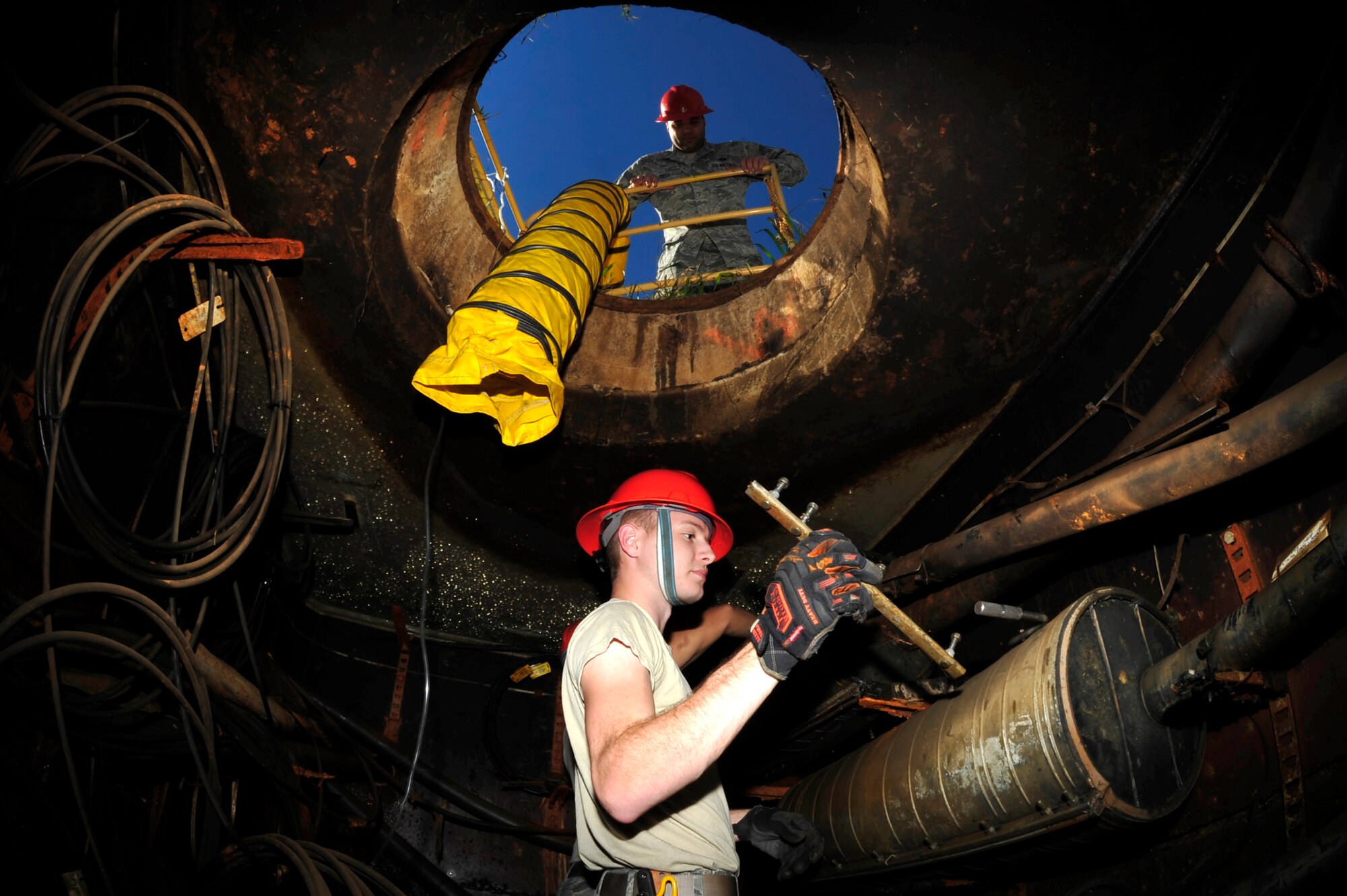 U.S. Air Force Staff Sgt. Elijah Toth, 633rd Communications Squadron antenna systems assistant noncommissioned officer in charge, supervises Airman 1st Class Zackery Dwyer, 633rd CS cable and antenna maintainer, at Langley Air Force Base, Va., Nov. 3, 2015. The manholes around Langley host a series of fiber and copper cables which are all connected to ensure communication and security vigilance. (U.S. Air Force photo by Senior Airman Breonna Veal/Released)