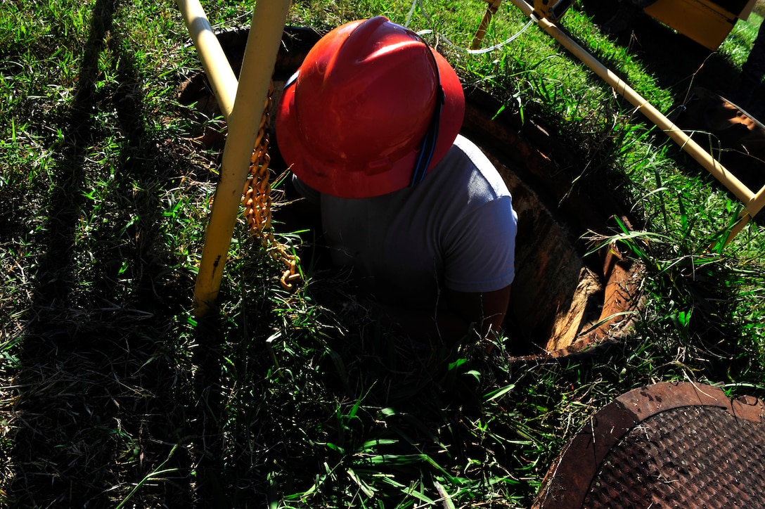 U.S. Air Force Airman 1st Class Alexander Acosta, 633rd Communications Squadron cable and antenna maintainer, climbs down a manhole at Langley Air Force Base, Va., Nov. 3, 2015. Airmen from the cable and antenna maintenance section, known as the “Cable Dawgs,” install, maintain, reconstitute, remove and modify copper core, coaxial, waveguide and fiber optic cable and antenna systems. (U.S. Air Force photo by Senior Airman Breonna Veal/Released)