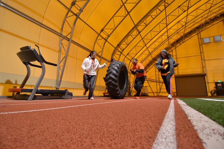Paula Krause (left), sexual assault response coordinator; Edward Vaughn, 50th Space Wing Equal Opportunity director; Staff Sgt. Zollie Mcneil, 50 SW EO; and Cecilia Smith, sexual assault victim advocate, roll a large tire the length of a running track during the Amazing gRace Friday, Oct. 30, 2015, in the indoor track at Schriever Air Force Base, Colorado. The race was a test of physical resilience, knowledge of world religion and random virtue-based trivia. (U.S. Air Force photo/2nd Lt. Darren Domingo)
