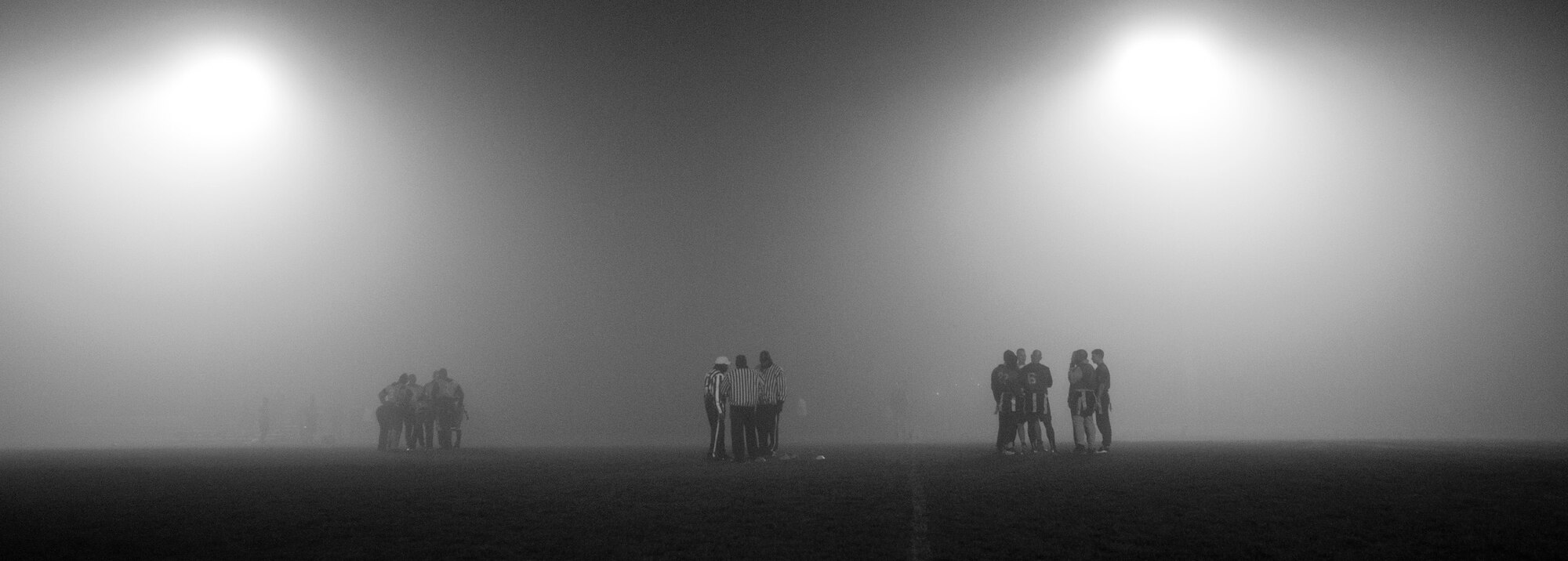 Members of the 52nd Communications Squadron and 52nd Civil Engineer Squadron Intramural Flag Football teams and officials huddle up during the 2015 Intramural Flag Football Championship game Nov. 3, 2015 at Spangdahlem Air Base, Germany. At halftime the 52nd CES led with a score of 13-0. (U.S. Air Force photo by Senior Airman Rusty Frank/Released)