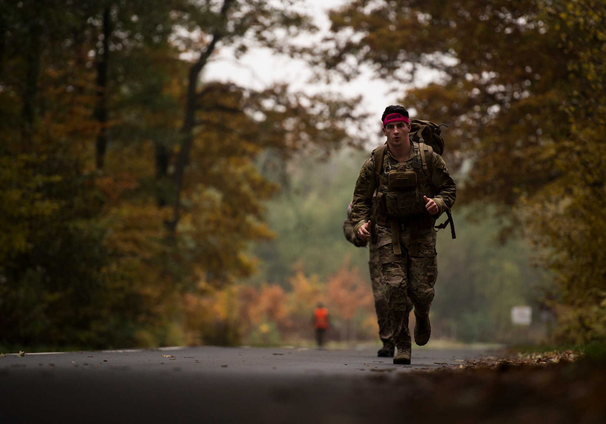 An explosive ordnance disposal ruck march participant jogs along a trail Oct. 30, 2015, at Ramstein Air Base, Germany. The ruck included events such as a six-foot wall climb and jerry can carry all while wearing a 50-pound pack. The intent of the event was to help raise money for the 2015 Combined Federal Campaign-Overseas. (U.S. Air Force photo/Senior Airman Jonathan Stefanko)