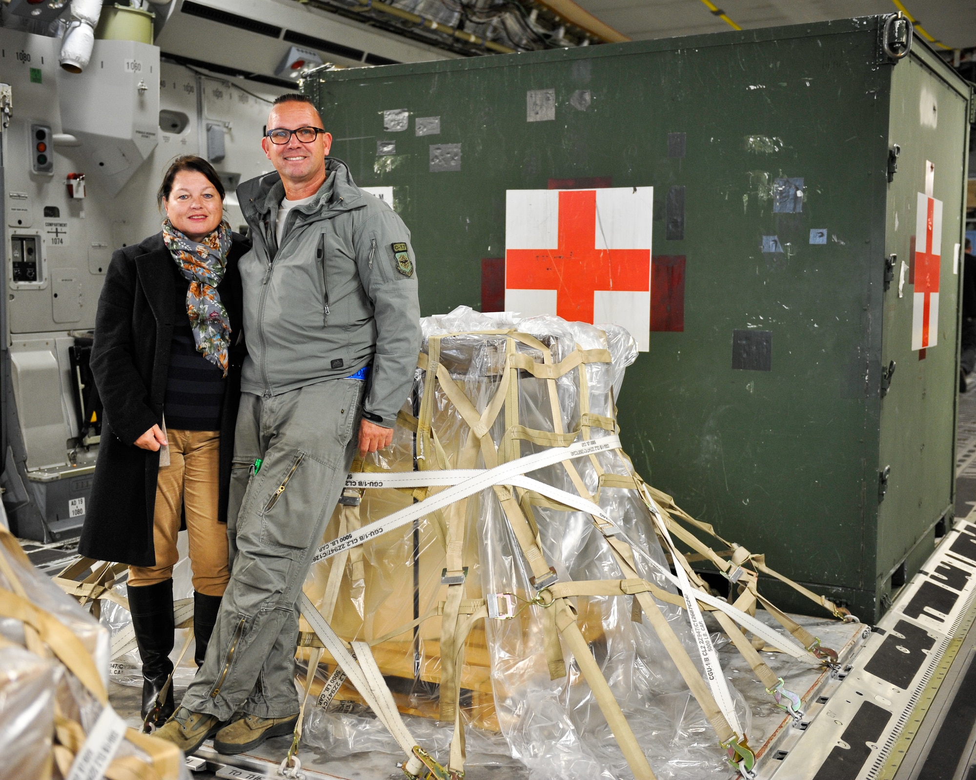 Kasper Chevalier, 721st Aerial Port Squadron aerial porter, shows his wife, Frieda Chevalier, what his day-to-day job on a C-17 Globemaster III entails Oct. 16, 2015, at Ramstein Air Base, Germany. Chevalier completed his 2,000th aerial port expeditor mission during this cargo load. (U.S. Air Force photo/Staff Sgt. Leslie Keopka)