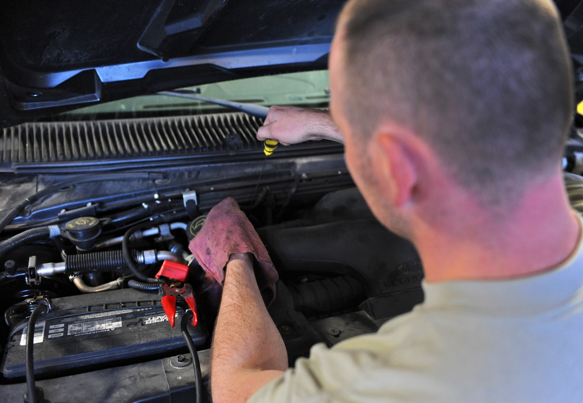 Senior Airman Jeremy Lee, 509th Logistics Readiness Squadron general purpose mechanic, checks the transmission fluid level in a government vehicle at Whiteman Air Force Base, Mo., Oct. 26, 2015. Fluid levels are checked regularly to ensure the functionality of engine components. (U.S. Air Force photo by Airman 1st Class Michaela R. Slanchik/Released)