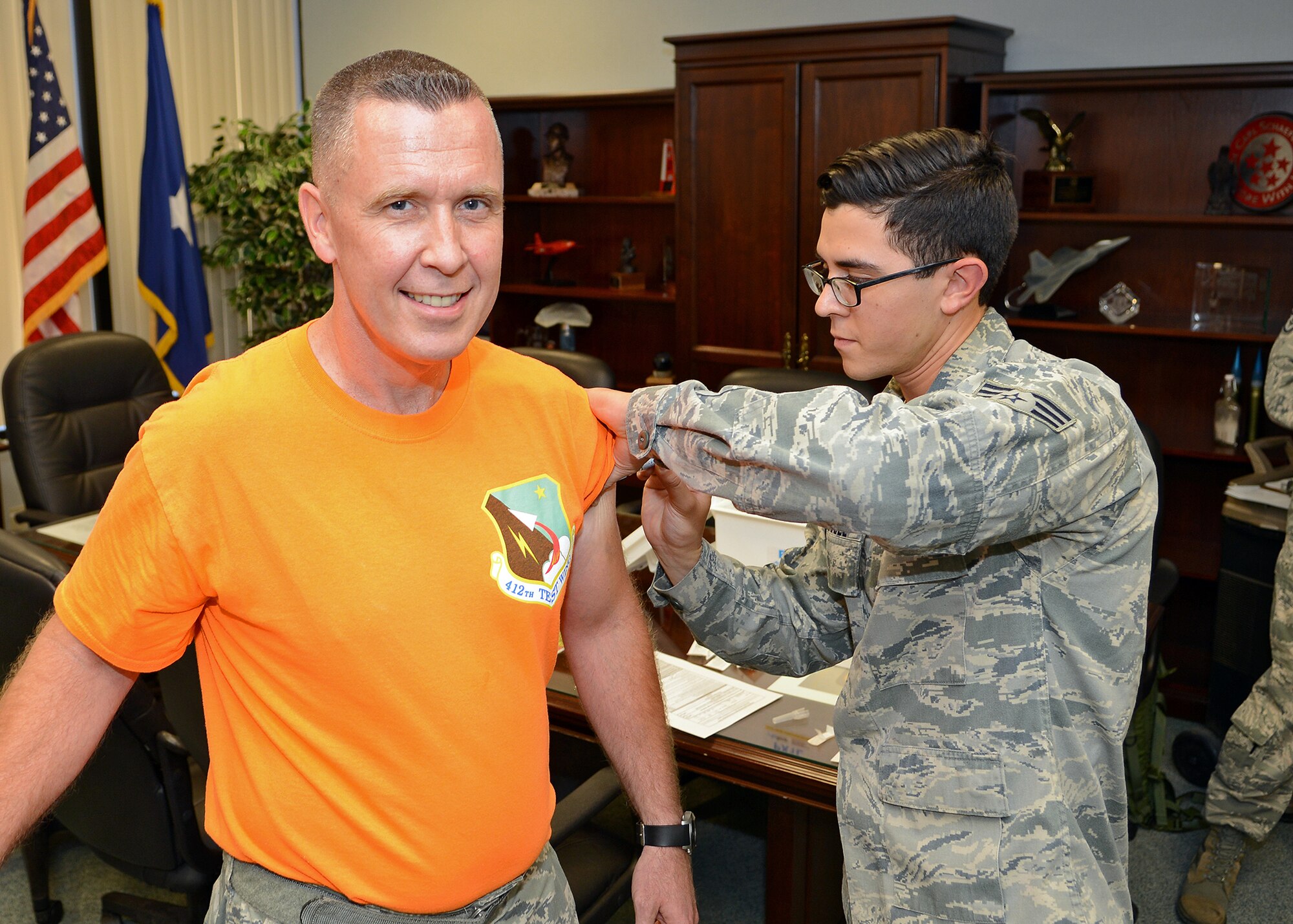 Chief Master Sgt. David Smith, 412th Test Wing command chief, receives his annual flu shot from Senior Airman Jeffrey Rodriguez, 412th Medical Operations Squadron. The 412th Medical Group will hold a walk-in vaccination drive Nov. 6, 2015, where Airmen can receive their flu shot. Tricare members 18 and older are also encouraged to get their flu shot. The drive will be held at the base theater from 8 a.m. to 3 p.m. (U.S. Air Force photo by Jet Fabara)