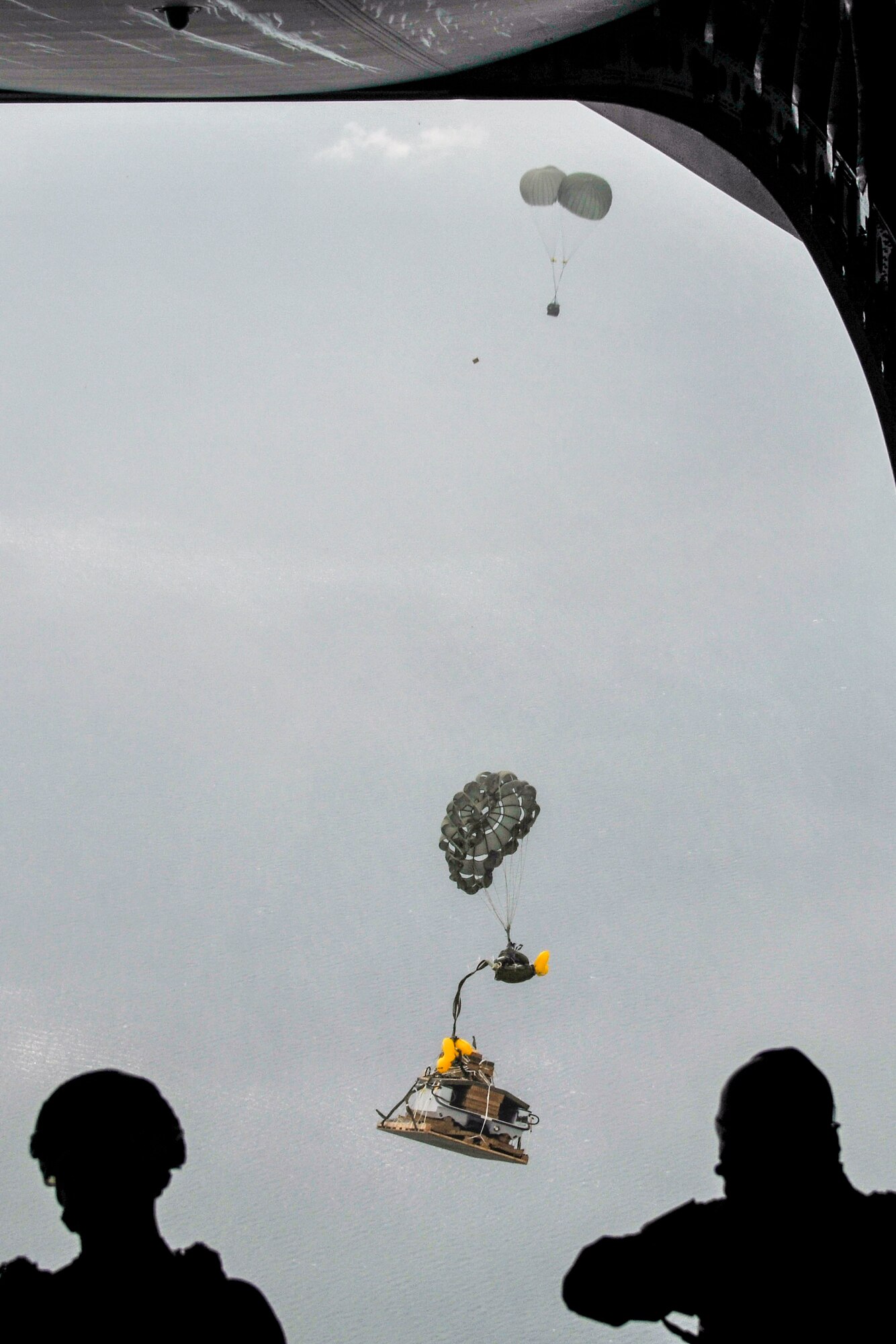 A Guardian Angel rescue craft and a rigged alternate method zodiac are airdropped out of a C-17 Globemaster from Alaska Air National Guard’s 249th Airlift Squadron Oct. 31, 2015, near the coast of White Beach Naval Base, Japan. The aircraft delivered a Guardian Angel rescue team from Alaska ANG’s 212th Rescue Squadron and equipment as part of a long-range search and rescue exercise. The 249th AS is the only C-17 unit qualified to deliver rescue jumpmaster procedures. (courtesy photo)