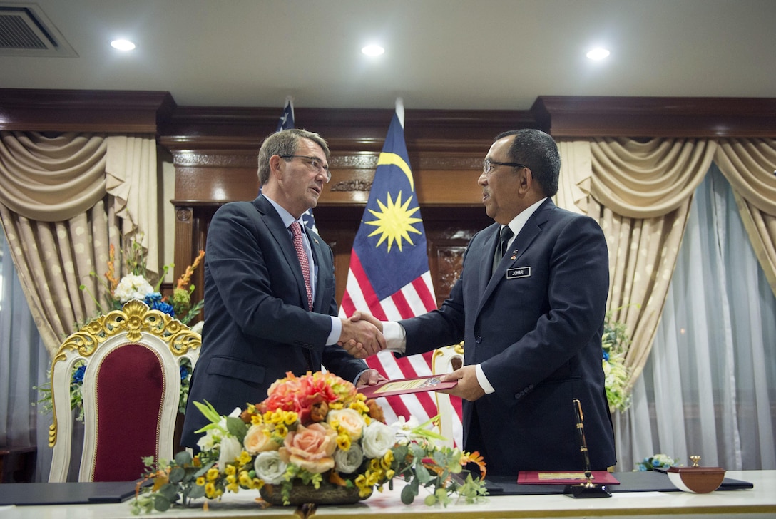 U.S. Defense Secretary Ash Carter and Malaysian Deputy Defense Minister Mohd Johari Baharum shake hands after signing documents transferring the remains of a recovered American World War II-era aircrew during a repatriation ceremony in Subang, Malaysia, Nov. 5, 2015. DoD photo by U.S. Air Force Senior Master Sgt. Adrian Cadiz