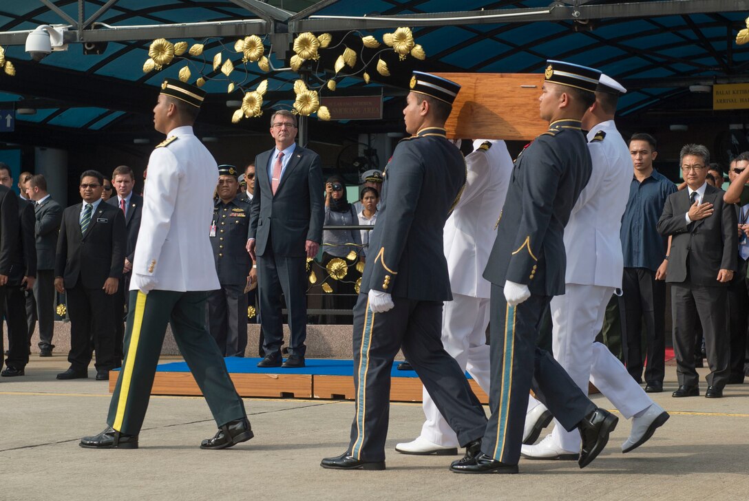 U.S. Defense Secretary Ash Carter stands by as a Malaysian carry team transfers the remains of a recovered American World War II-era aircrew to a U.S. carry team during a repatriation ceremony in Subang, Malaysia, Nov. 5, 2015. DoD photo by U.S. Air Force Senior Master Sgt. Adrian Cadiz