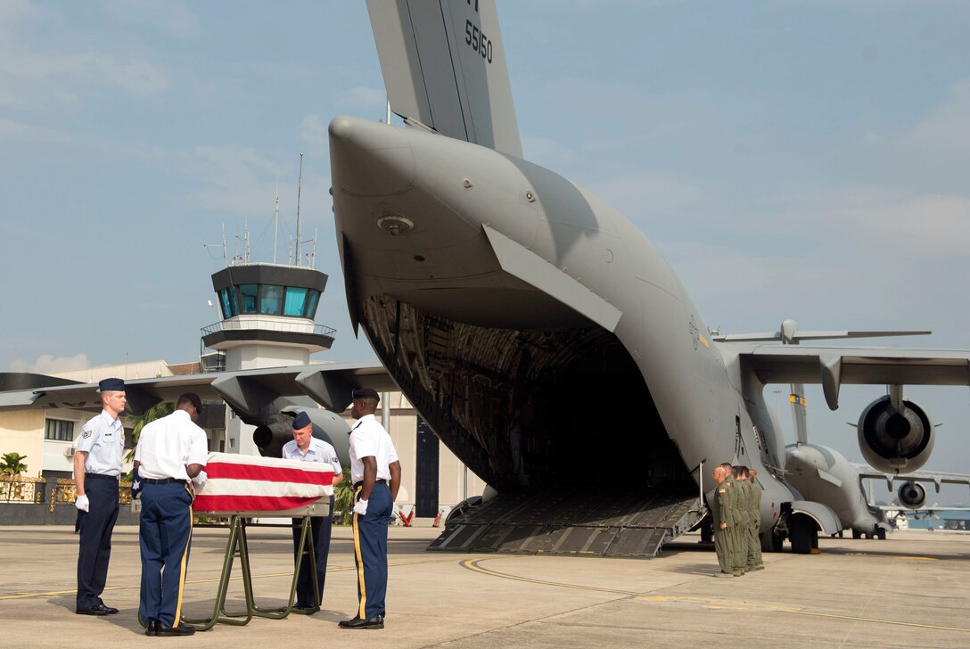 Members of a joint carry team drape an American flag over a transfer case of a recovered American World War II-era aircrew during a repatriation ceremony in Subang, Malaysia, Nov. 5, 2015. DoD photo by U.S. Air Force Senior Master Sgt. Adrian Cadiz