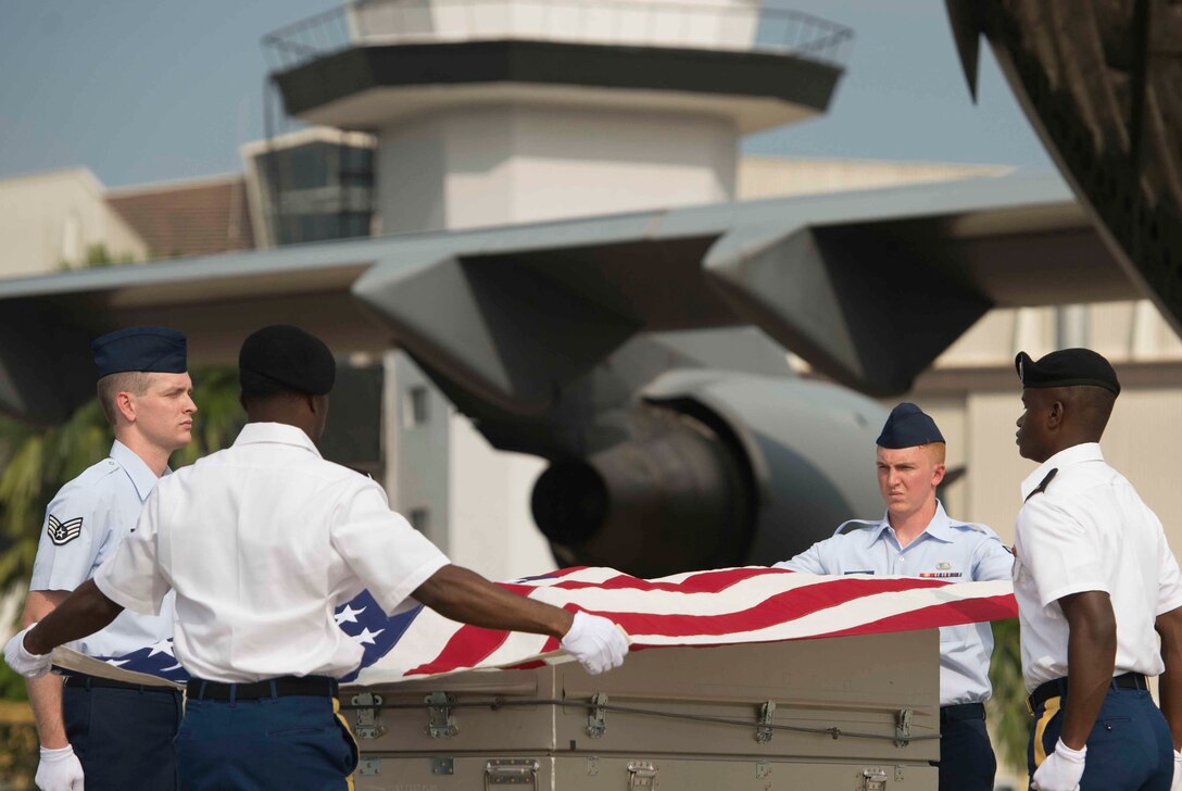 Members of a joint carry team drape an American flag over a transfer case of a recovered American World War II era aircrew during a repatriation ceremony in Subang, Malaysia, Nov. 5, 2015. DoD photo by U.S. Air Force Senior Master Sgt. Adrian Cadiz