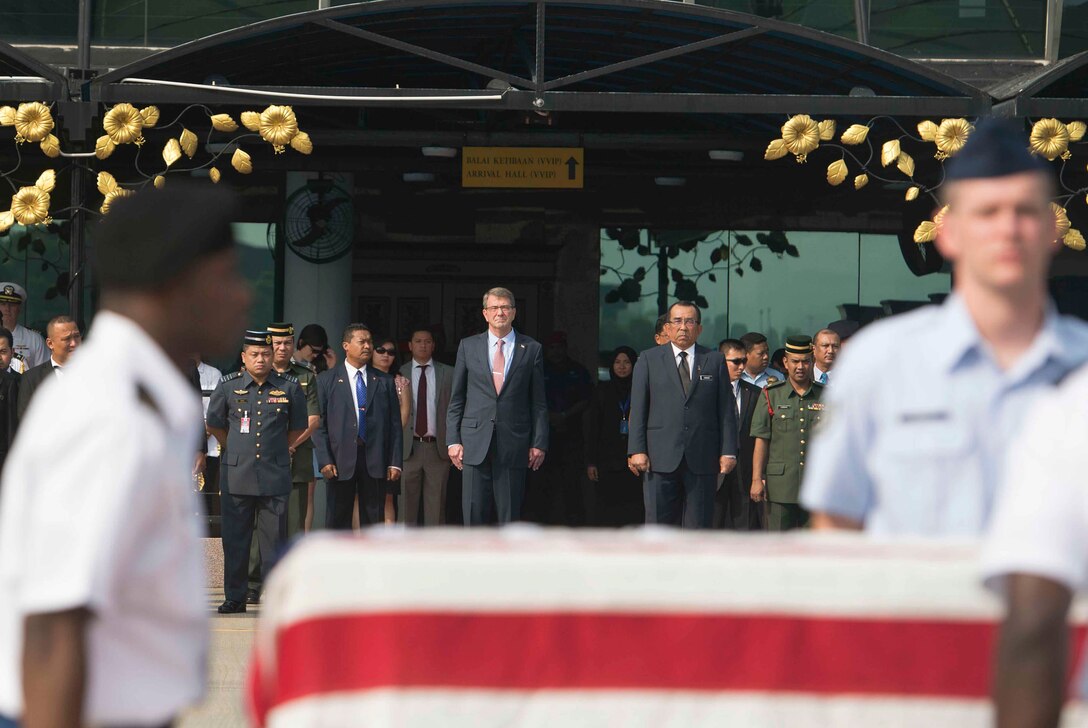 U.S. Defense Secretary Ash Carter, left, watches as a joint carry team drapes an American flag over a transfer case of a recovered American World War II era aircrew during a repatriation ceremony in Subang, Malaysia, Nov. 5, 2015. DoD photo by U.S. Air Force Senior Master Sgt. Adrian Cadiz