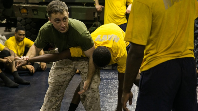 U.S. Marine Sgt. Justin Leduc demonstrates a take-down technique aboard the USS Essex on the Gulf of Oman, Oct. 31, 2015 during a non-lethal force course. Leduc is the non-commissioned-officer-in-charge for the Law Enforcement Detachment, Combat Logistics Battalion 15, 15th Marine Expeditionary Unit. The course includes different techniques Navy and Marine watch-standers can utilize on aggressors before escalating to lethal force.
